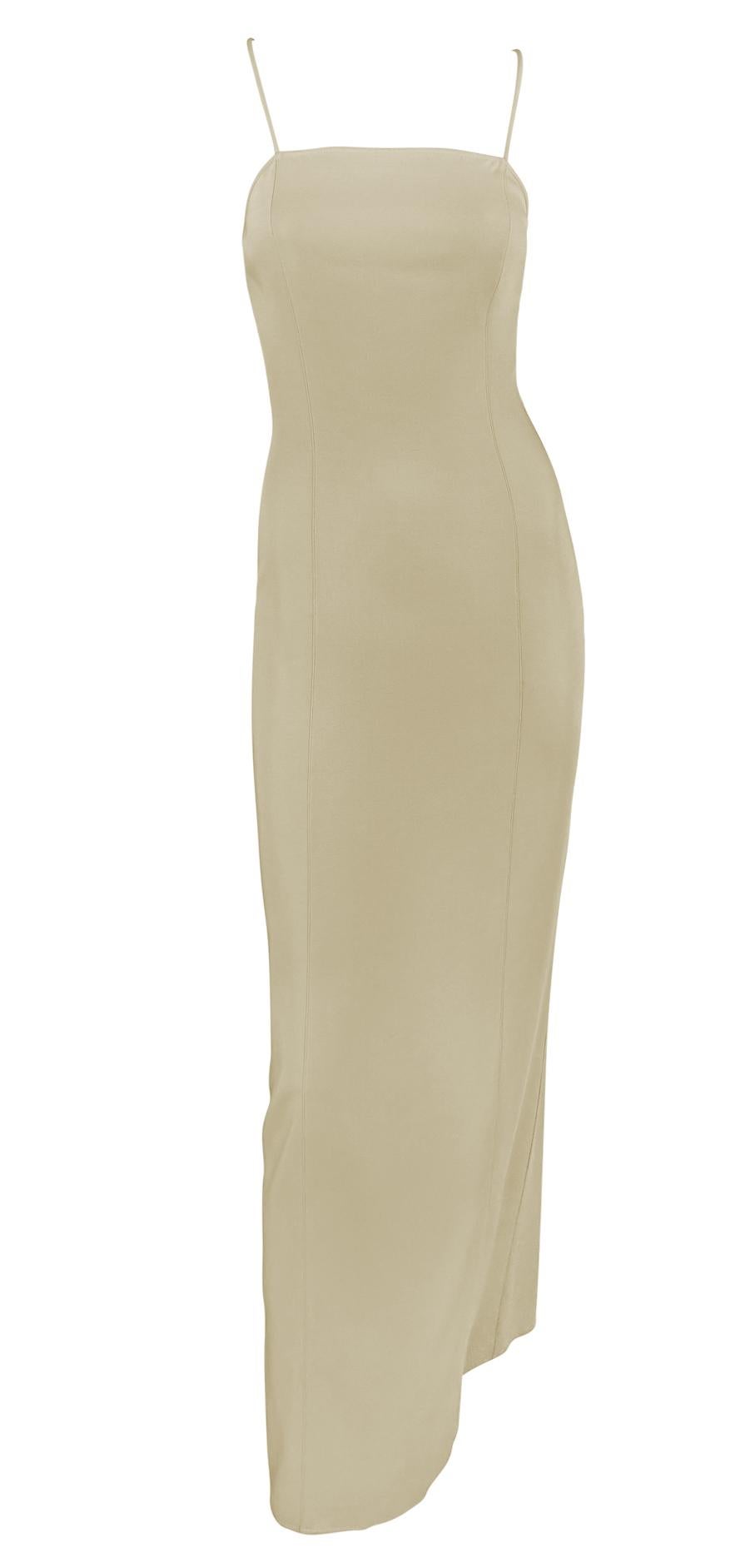 Este vestido Giorgio Armani de finales de los 90 está confeccionado en una fluida mezcla de seda beige con una silueta minimalista. El vestido presenta delicados tirantes finos que se cruzan en la espalda y un corte columna que se adapta suavemente