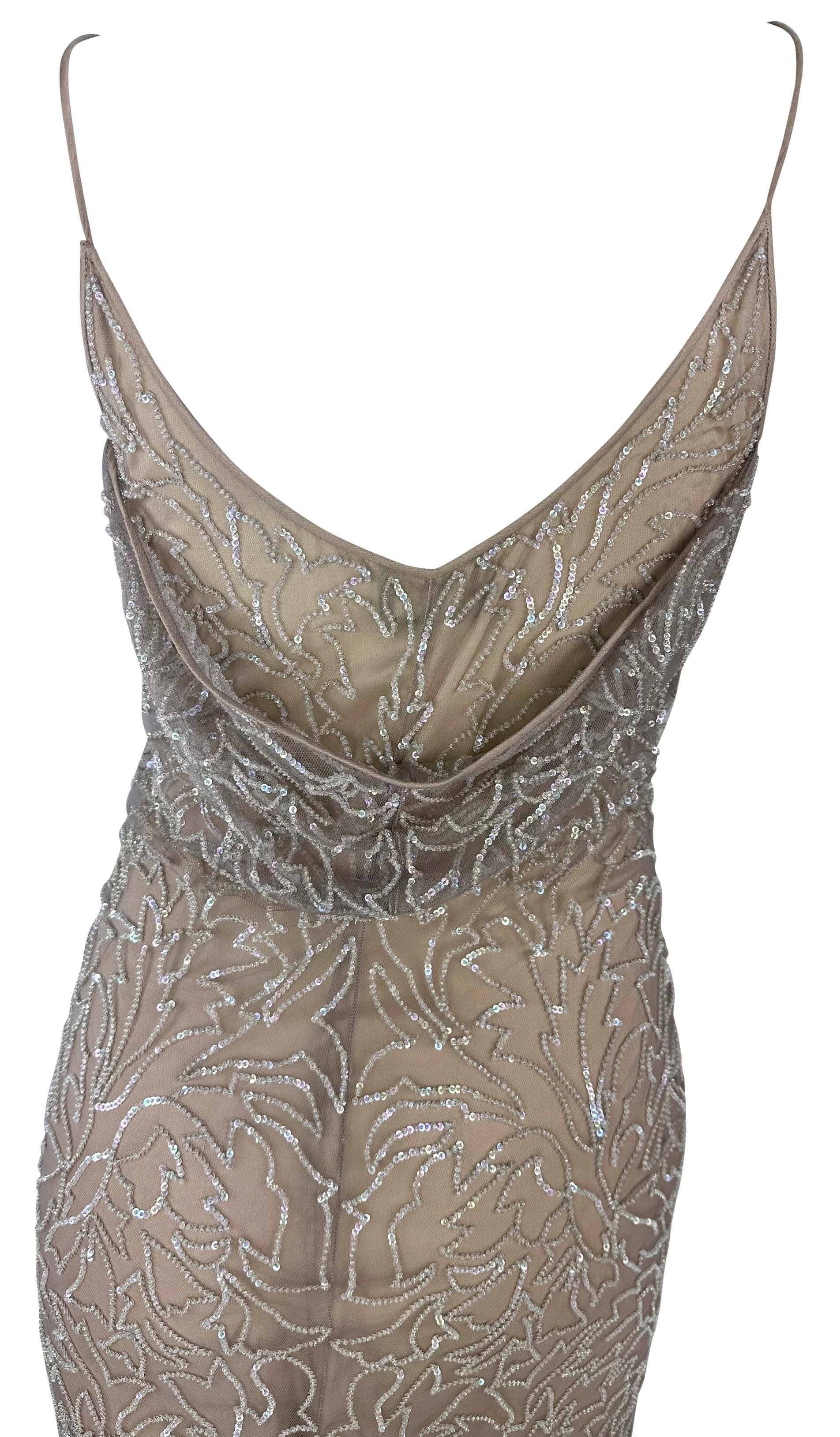This beige Giorgio Armani gown from the late 1990s is a beautiful piece adorned with a floral print that sparkles with thousands of meticulously hand-sewn sequins. Its slip-style design boasts delicate thin straps, a graceful low scoop neckline, and