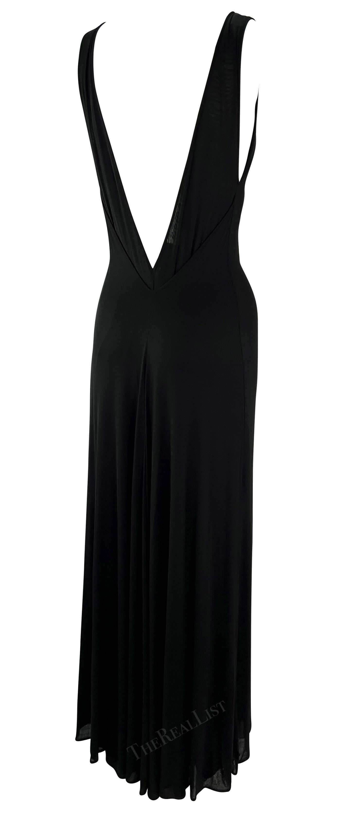 Presenting a stunning black Giorgio Armani Black slip gown. From the late 1990s, this fabulous knit stretch dress features a wide scoop neckline. The dress is amped up with a deep plunging back that tapers to a v-shape leaving the back exposed. The