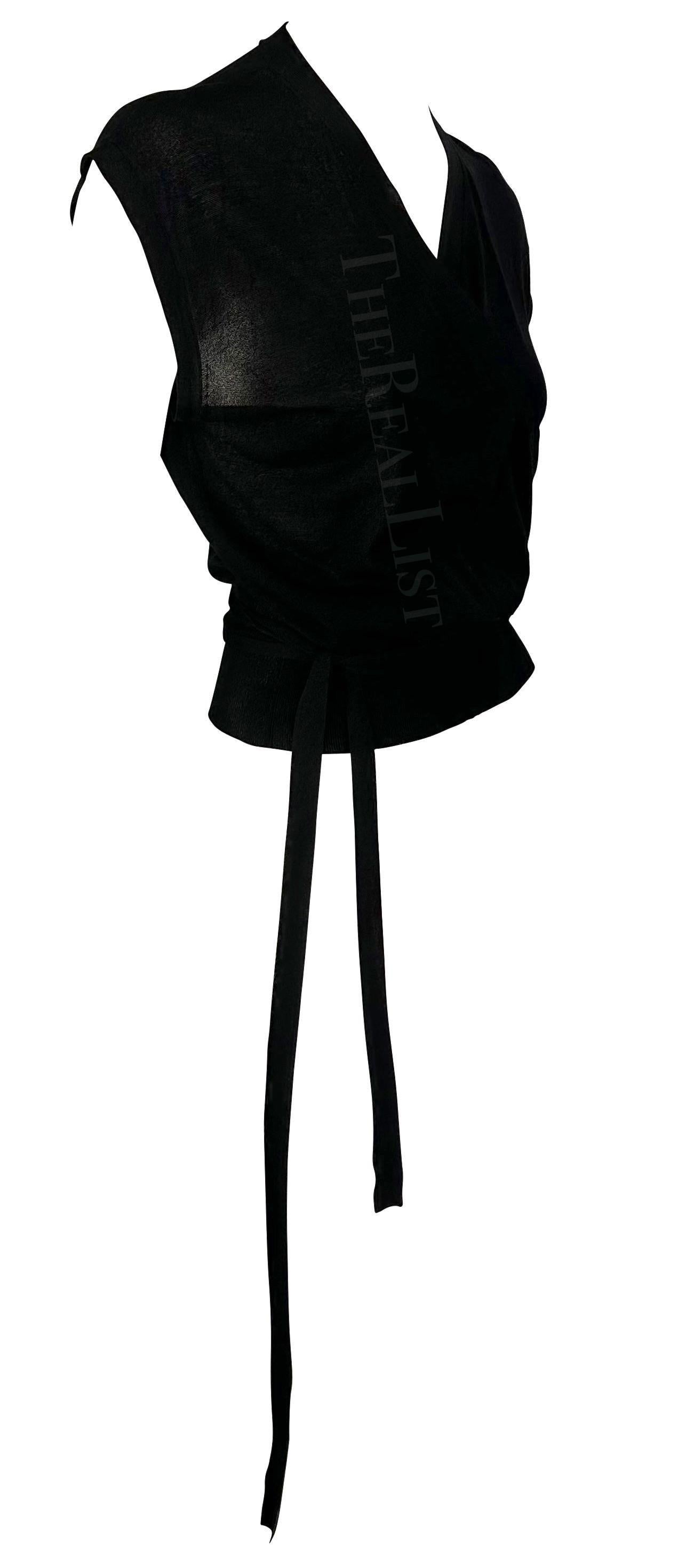 Te presentamos un elegante top negro de punto de Gucci, diseñado por Tom Ford. De finales de la década de 1990, este top está confeccionado totalmente en punto de seda y se envuelve en la parte delantera. Este lujoso top tiene mangas estilo pétalo,