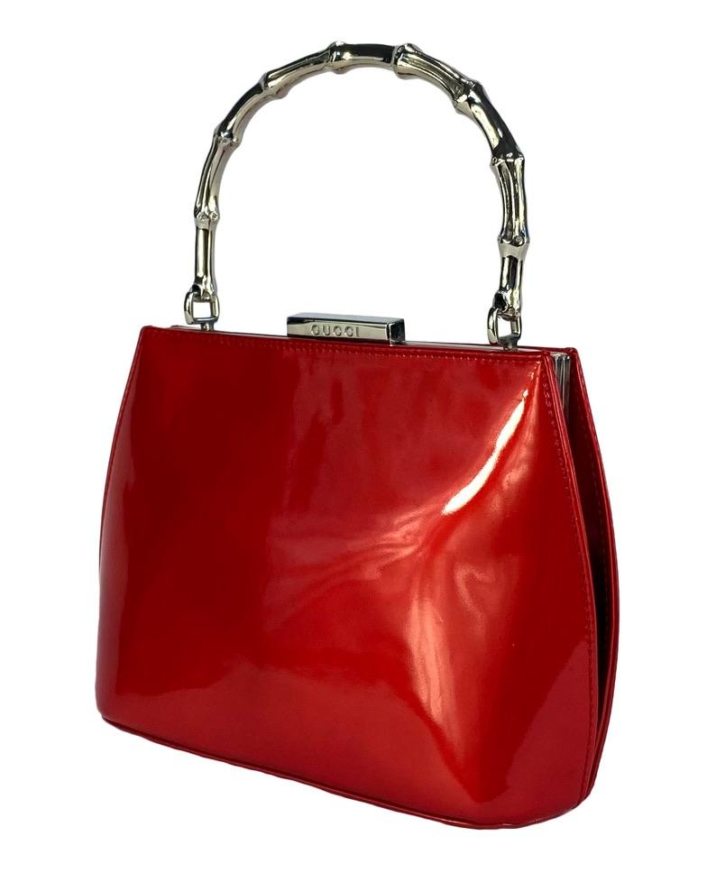 TheRealList presents: a bright red patent leather Gucci bag with a silver bamboo handle, designed by Tom Ford. From the late 1990s, likely 1995, this mini Gucci bag is reminiscent of earlier house designs but has been refined and elevated with