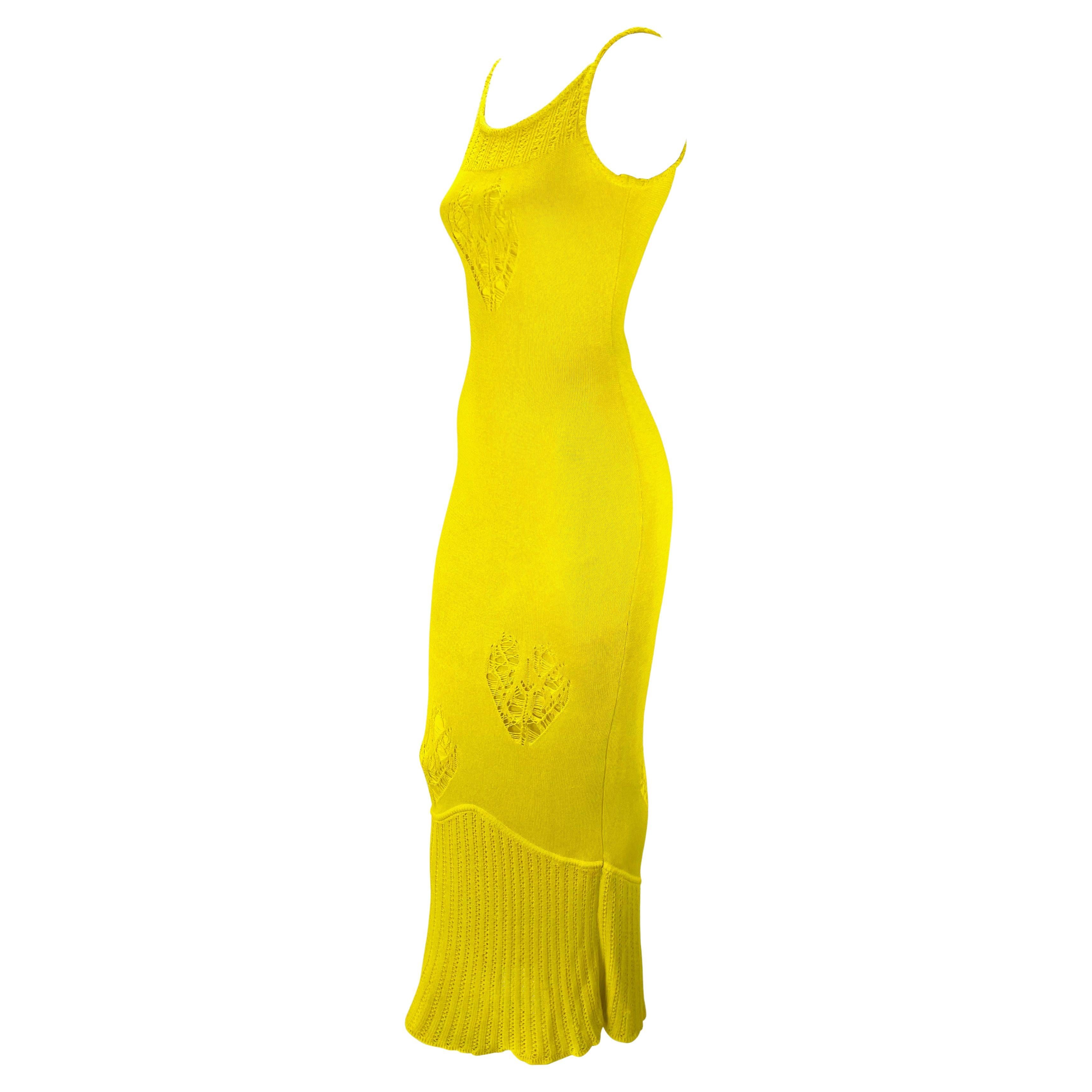 Elle présente une magnifique robe en tricot jaune canari de John Galliano. Issue de la collection printemps/été 2000 de Galliano, cette robe en maille est dotée d'une large encolure et d'un dos échancrés. La robe présente différents motifs de tricot