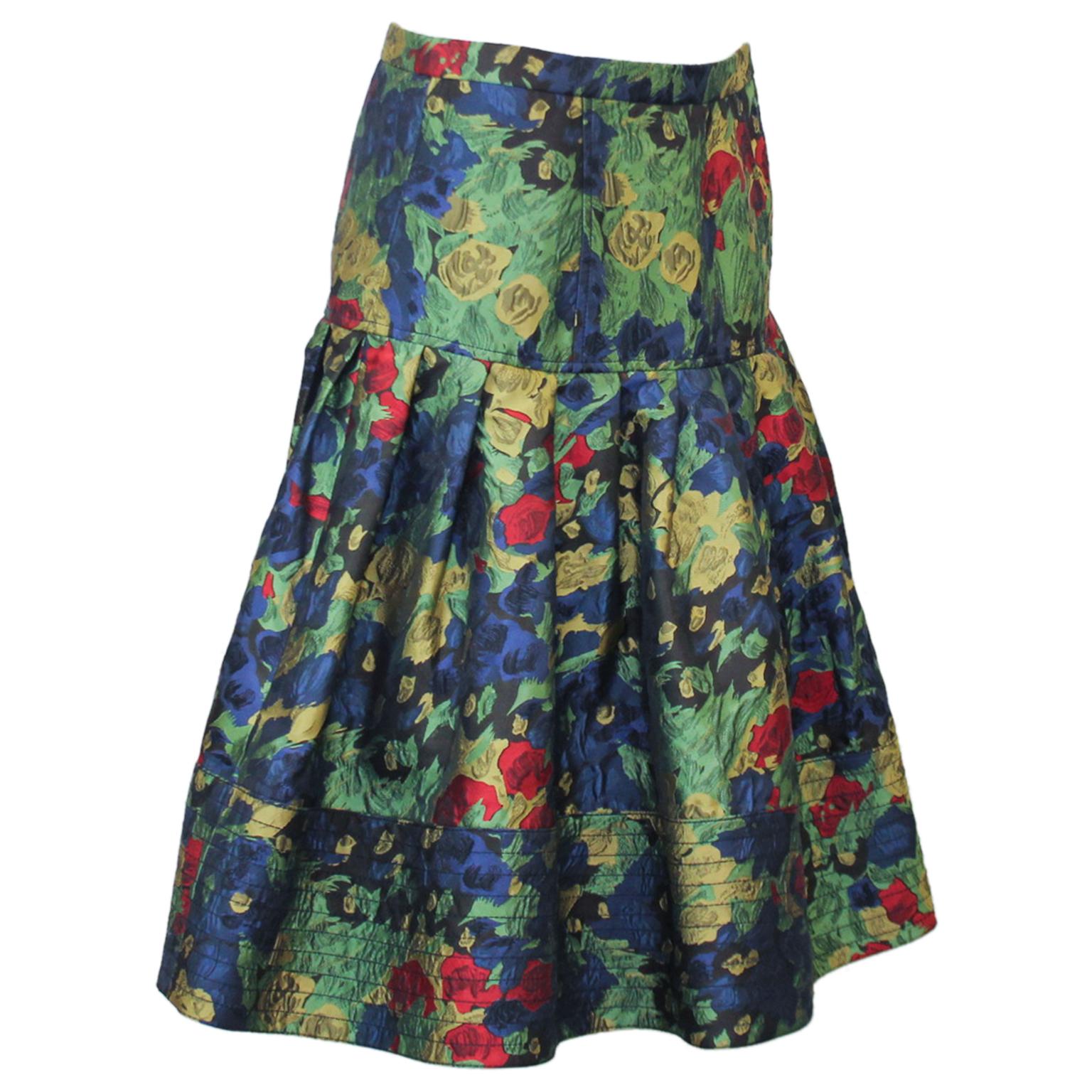 Late 1990s Oscar de la Renta flared skirt with a vibrant floral pattern on a black background. The luscious silk brocade fabric gives the skirt its amazing shape. Fitted through the hips with a pleated drop waist and finished with a black