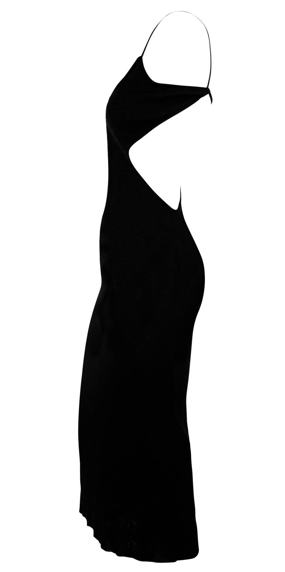 This late 1990s Richard Tyler bodycon dress is crafted from black lurex knit, offering a shimmering finish and a sleek, form-fitting silhouette. The design features a daring deep side cutout that extends from the waist to the back, connected by a