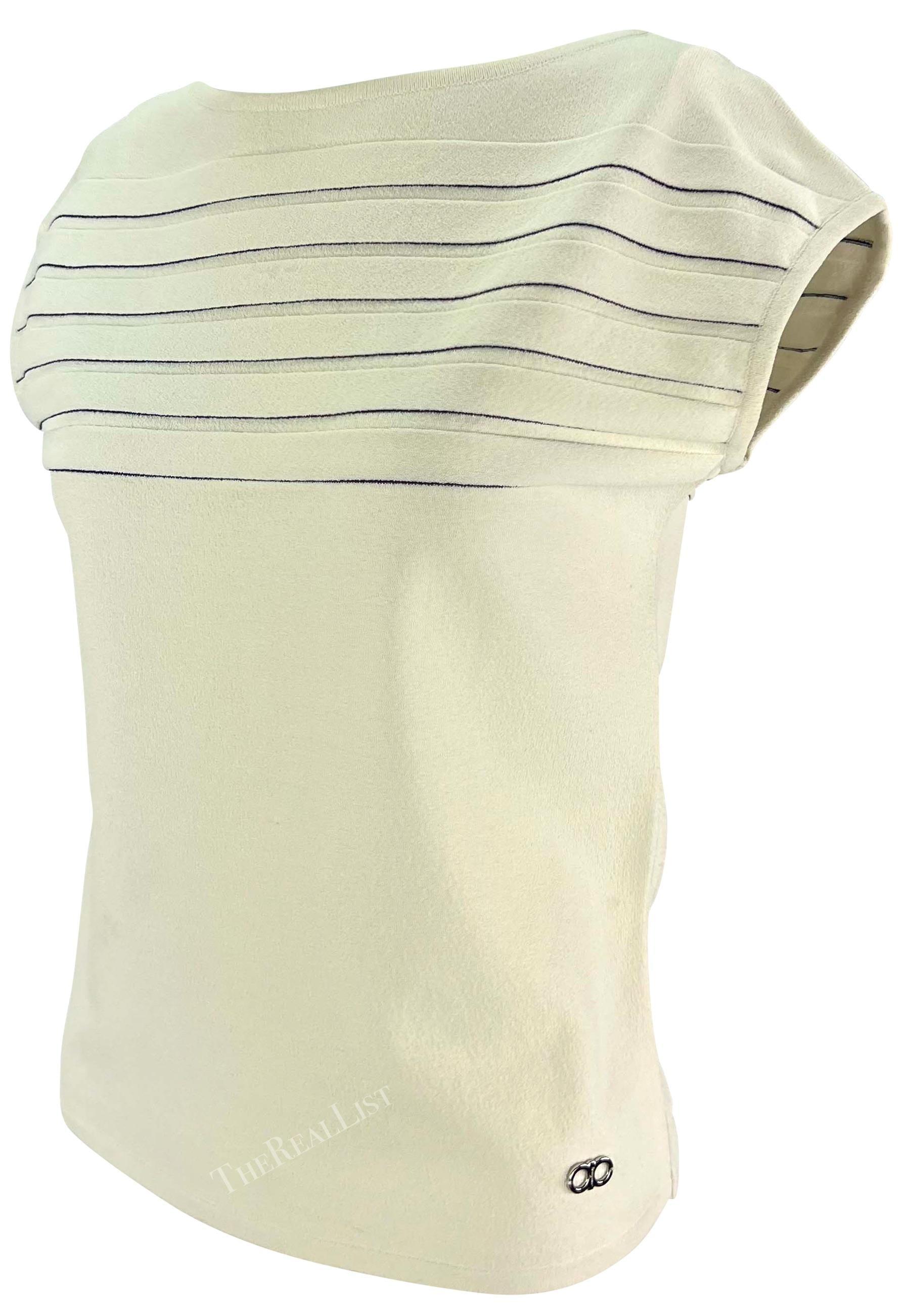 Ti presentiamo un top a righe di Salvatore Ferragamo in maglia bianca. Questo top bianco sporco, risalente agli anni '90, è caratterizzato da sottili strisce marinare che attraversano il busto e da maniche a petalo. Il top è completato da un piccolo