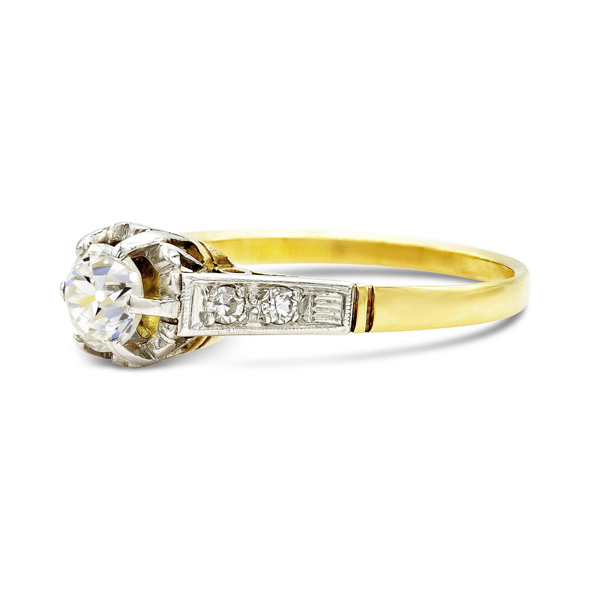 This antique engagement ring is romance personified. A buttercup setting holds a mesmerizing 0.67 ct. old European cut featuring a high crown and so much personality. With its diamond-studded shoulders and metalwork, this two-tone setting is a