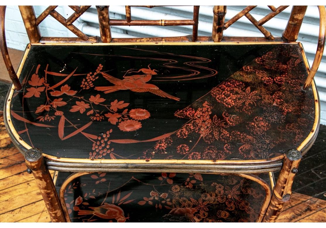A fine antique étagère with good proportions and condition. The Chinese Chippendale form holds three painted and lacquered shelves which portray birds, branches, leaves and a little frog. All of the painting is executed in a Cinnebar shade against a