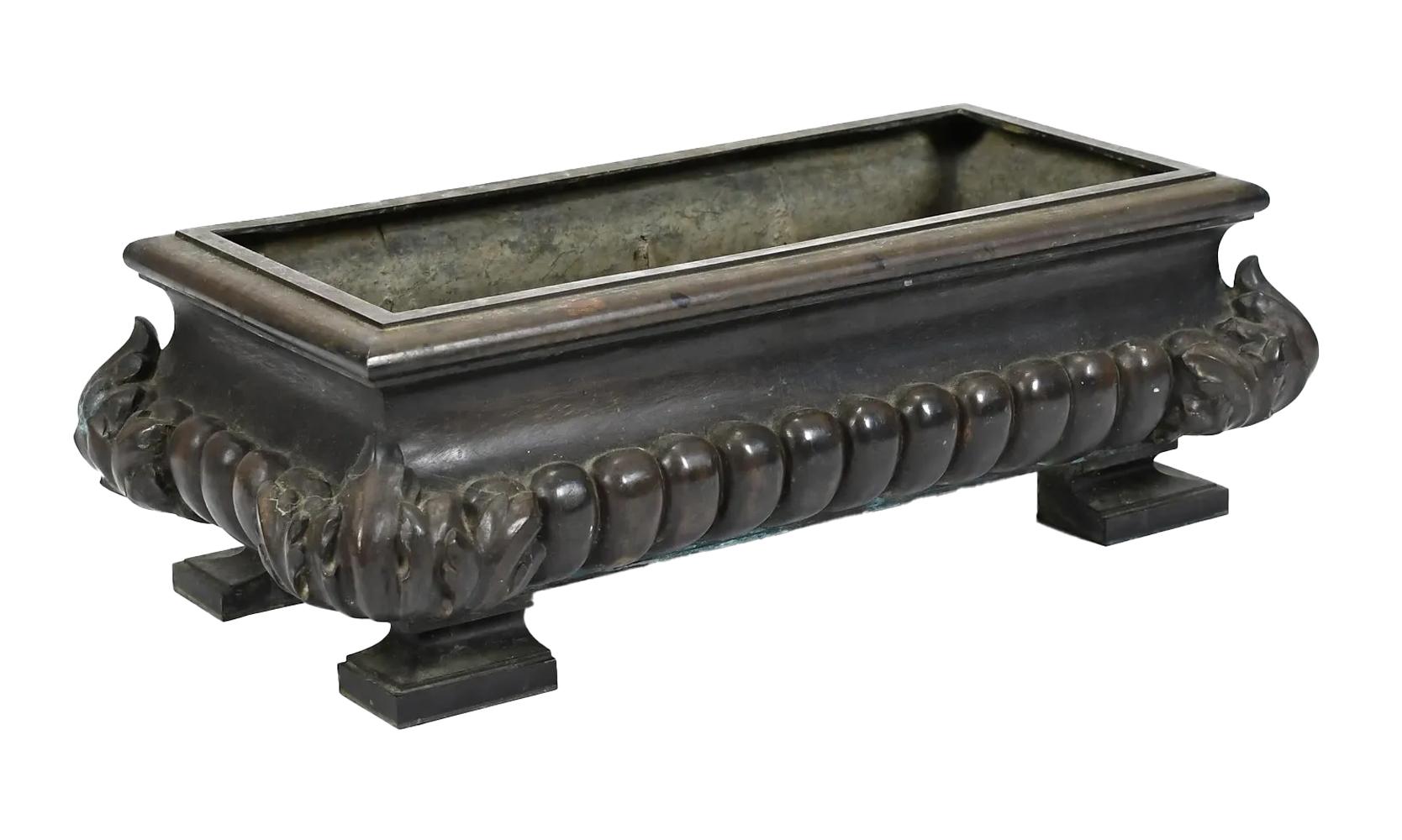 19th Century Neoclassical heavy patinated cast bronze planter of large scale having gadrooned bombe sides with acanthus leaf corners raised on block feet. Suitable for indoor as well as outdoor use.