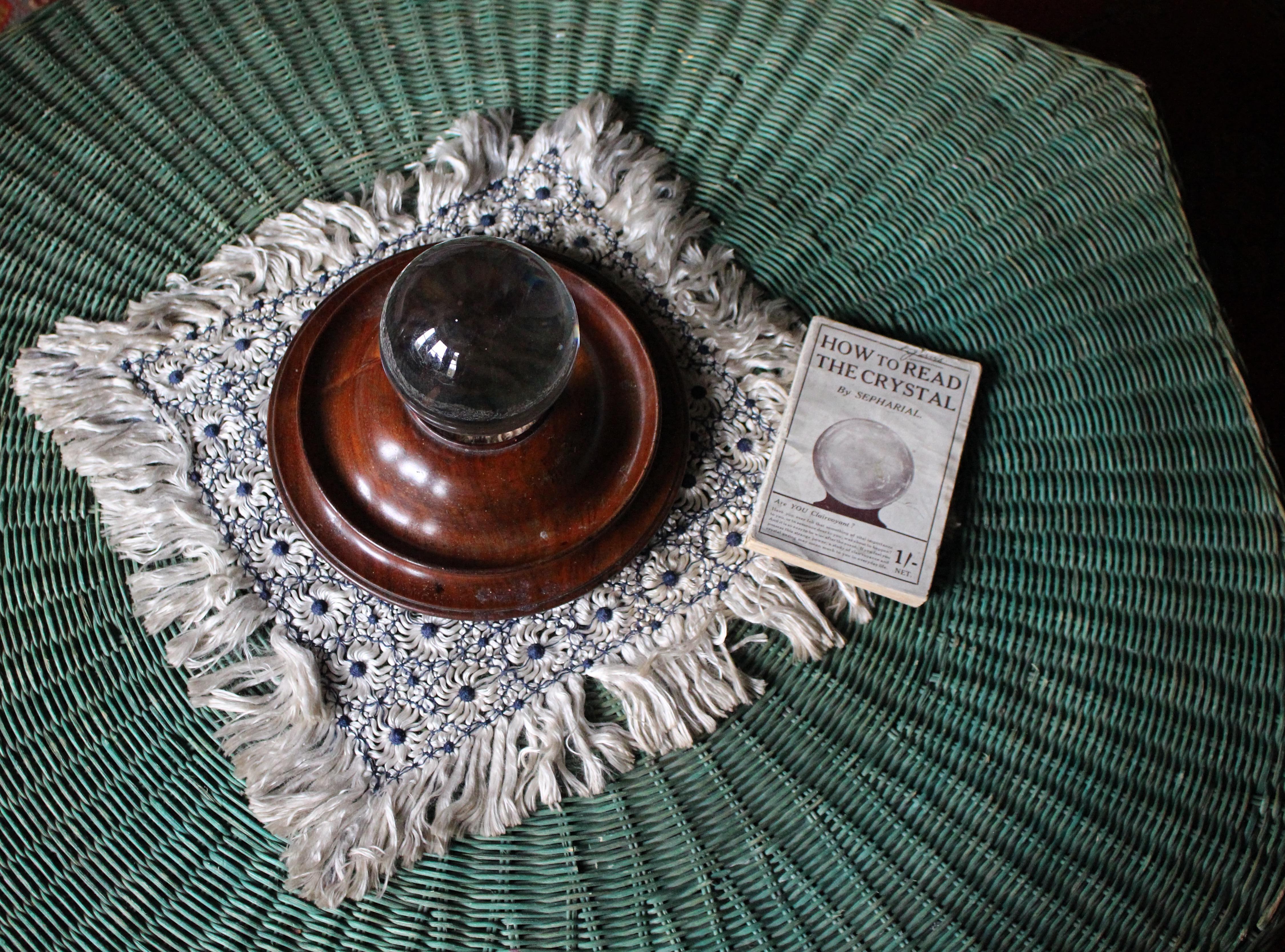 A wonderful and rare late 19th, possibly very early 20th century fortune tellers crystal ball.

The large crystal ball sits on its original turned mahogany stand, that in turn sits on three solid ceramic bun feet. A faux lizard skin covers the base,