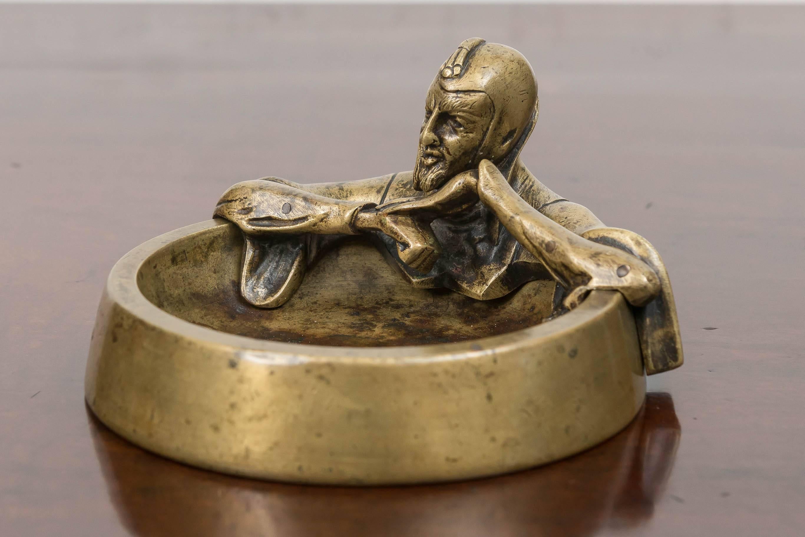 Late 19th C Effigy of Mephistopheles on a bronze dresser tray. Leaning into the tray with a contemplative pose and conniving expression. Best known for his role in Faust. Caught in his own hell as an agent of Lucifer. Though an agent of Lucifer he