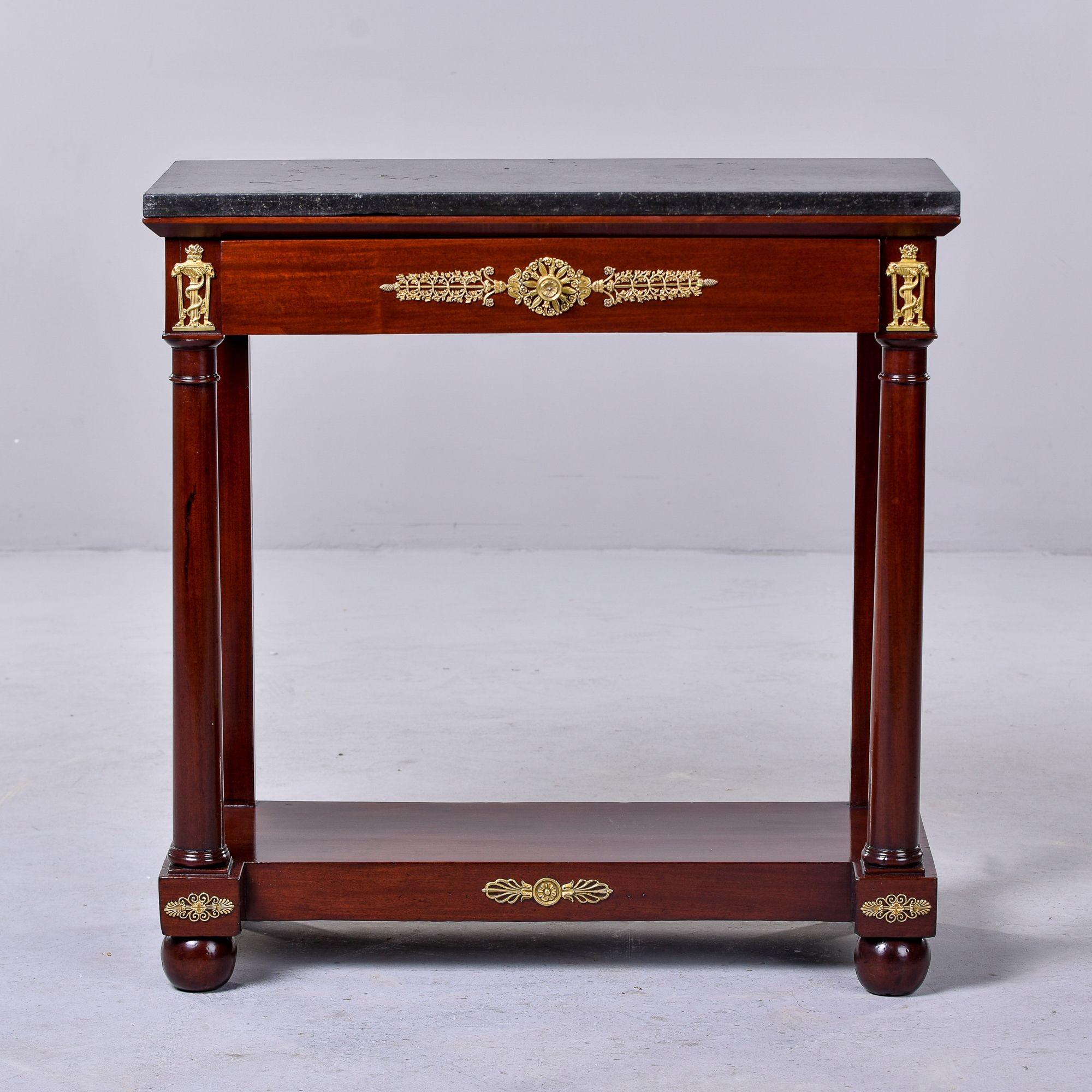 Found in France, this circa 1890s console has a mahogany base with gilt bronze decorative mounts, ball feet on the front, a single drawer with dovetail construction and a black slate top. Unknown maker. 
 
Overall very good antique condition -