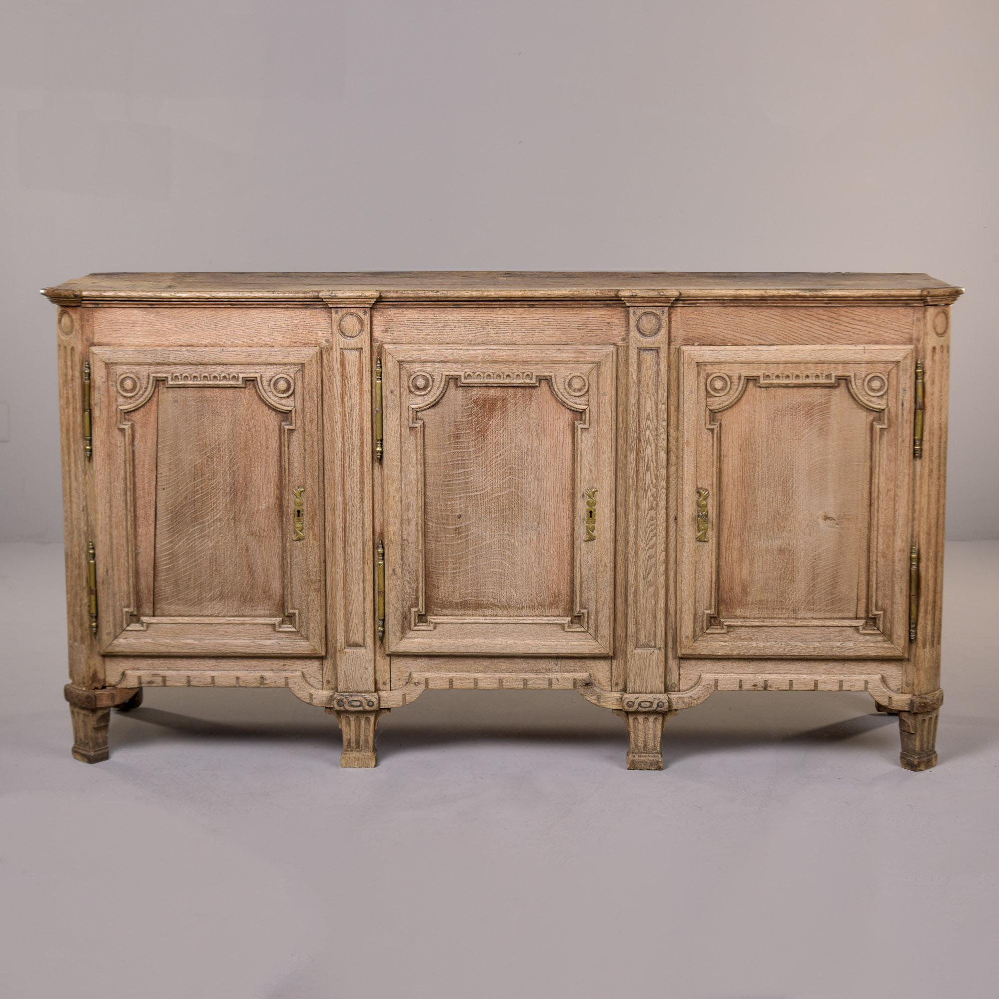Dieser Buffetschrank aus Eiche wurde in Frankreich gefunden und stammt aus den 1880er Jahren. Gefertigt aus alter französischer Eiche, die leicht gebleicht, entlackt und glatt geschliffen wurde. Drei aufklappbare und verschließbare Schranktüren