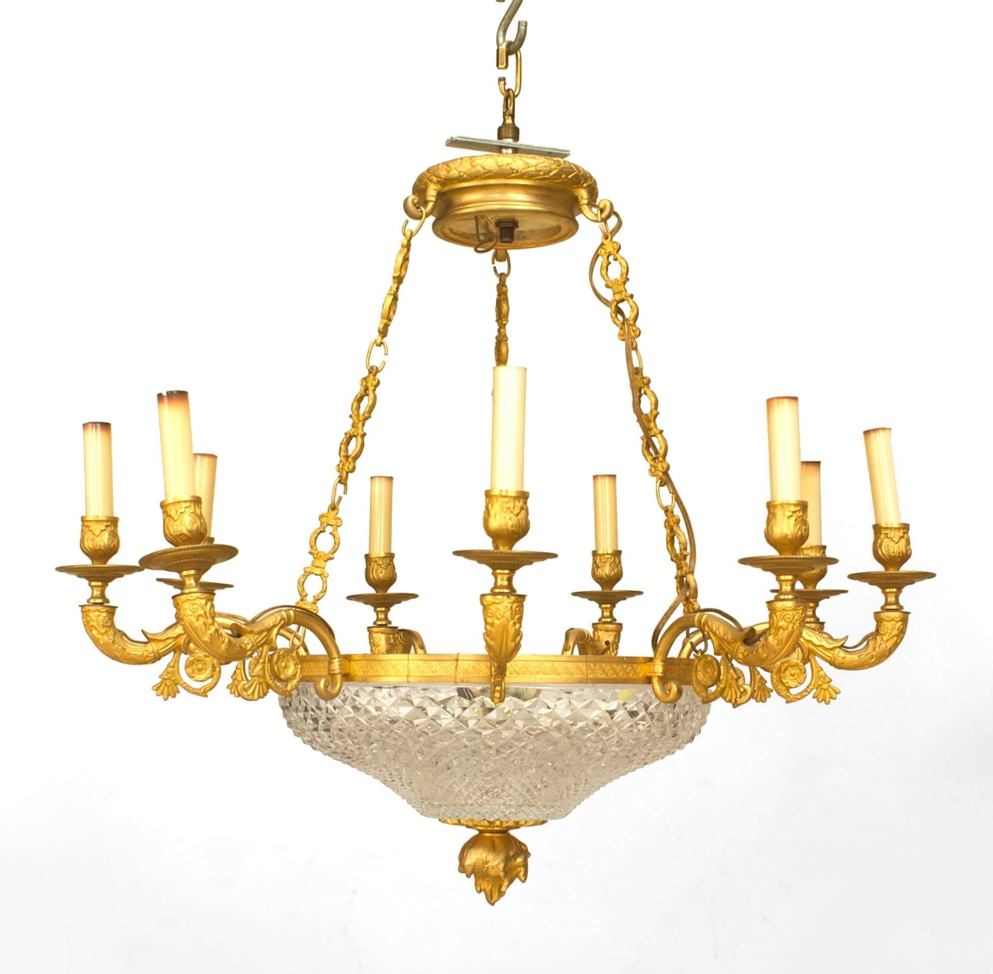 French Empire-style (late 19th Century) gilt bronze chandelier with a cut crystal bowl supporting a ring of 8 scroll arms suspended by 3 chains to a canopy with a flame final bottom.
