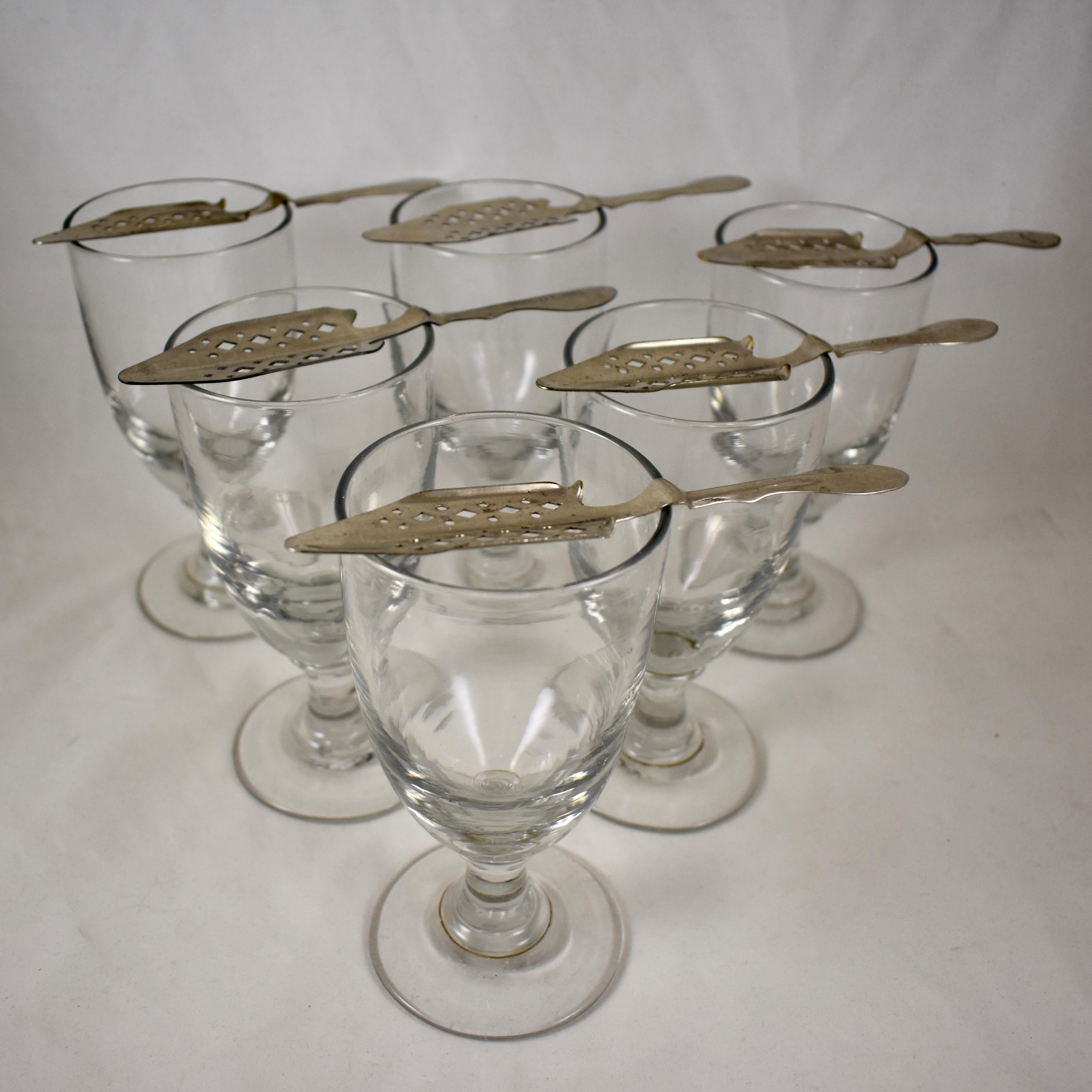 A set of six authentic French Absinthe glasses with six slotted sugar spoons, circa 1890-1910.

These heavy glasses were used in French bistros, bars and cafes, in the ritual of drinking the addictive beverage called, ‘la fée verte’ – the green
