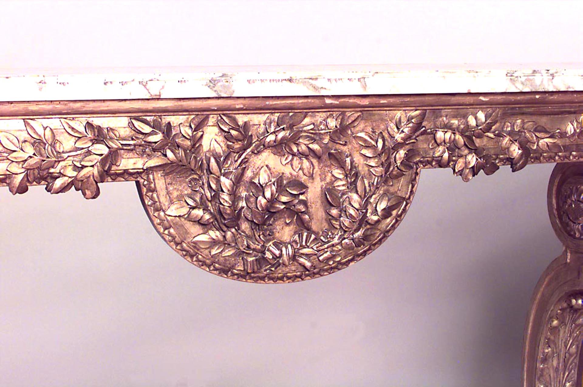 French Louis XVI-style (Late 19th Century) giltwood console table with white marble top above a laurel wreath carved frieze on voluted legs joined by a stretcher with basket
