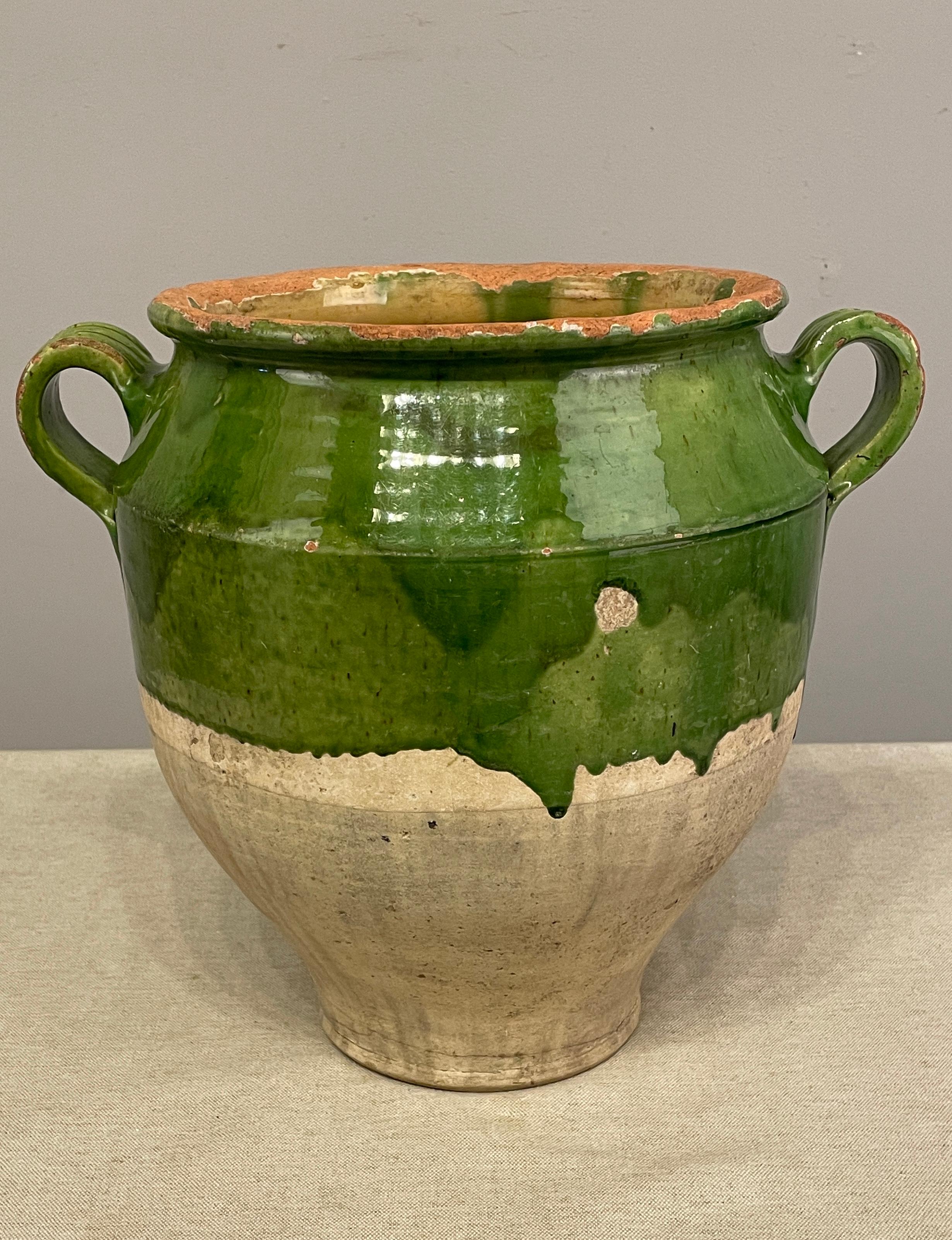 An earthenware confit pot from the Southwest of France with traditional green glaze . Minor chips and losses to glaze. These ordinary earthenware vessels were once used daily in the French country home and have beautiful rustic glazes of green,