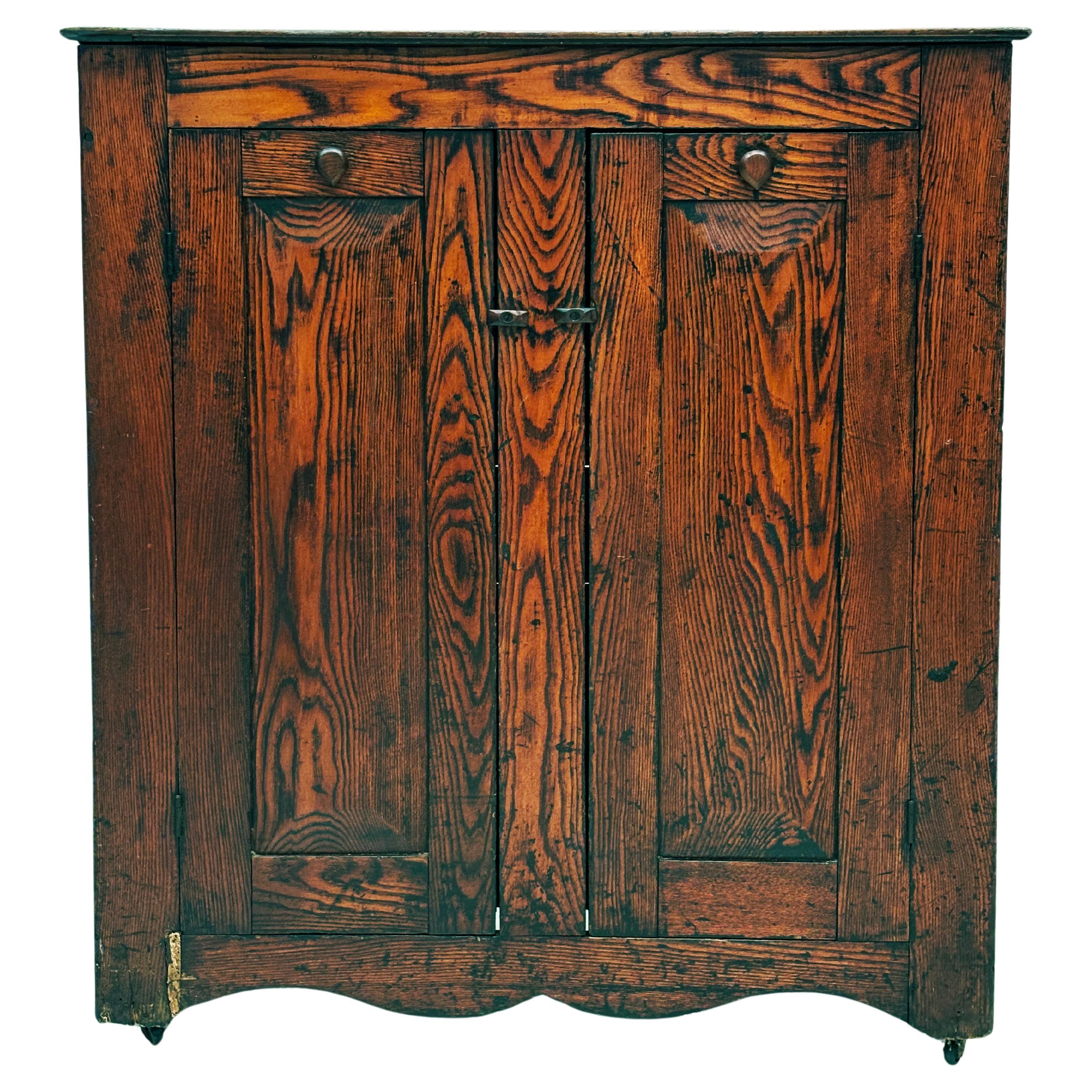This very unique primitive jelly cupboard is made of deeply figured pine with richly colored wood and a simple design, most likely made in the northern part of the United States in the last 1800's. This piece would have been found in a country