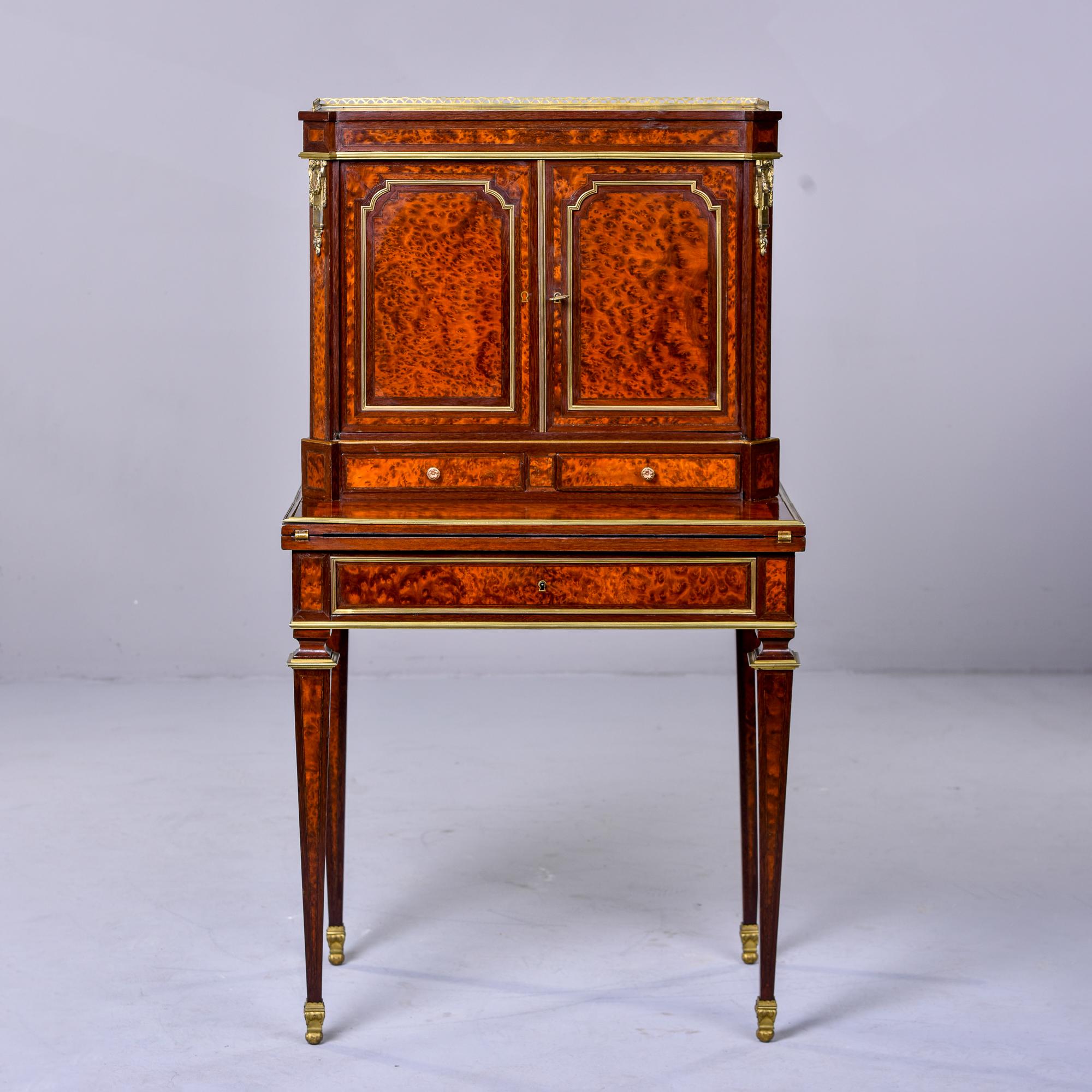 Circa 1890s French secretary desk or bonheur du jour (translates to daytime delight) in mahogany and brass. Top section has a brass gallery, decorative brass trim and mounts. Two hinged locking doors open to storage space with a single fixed shelf.