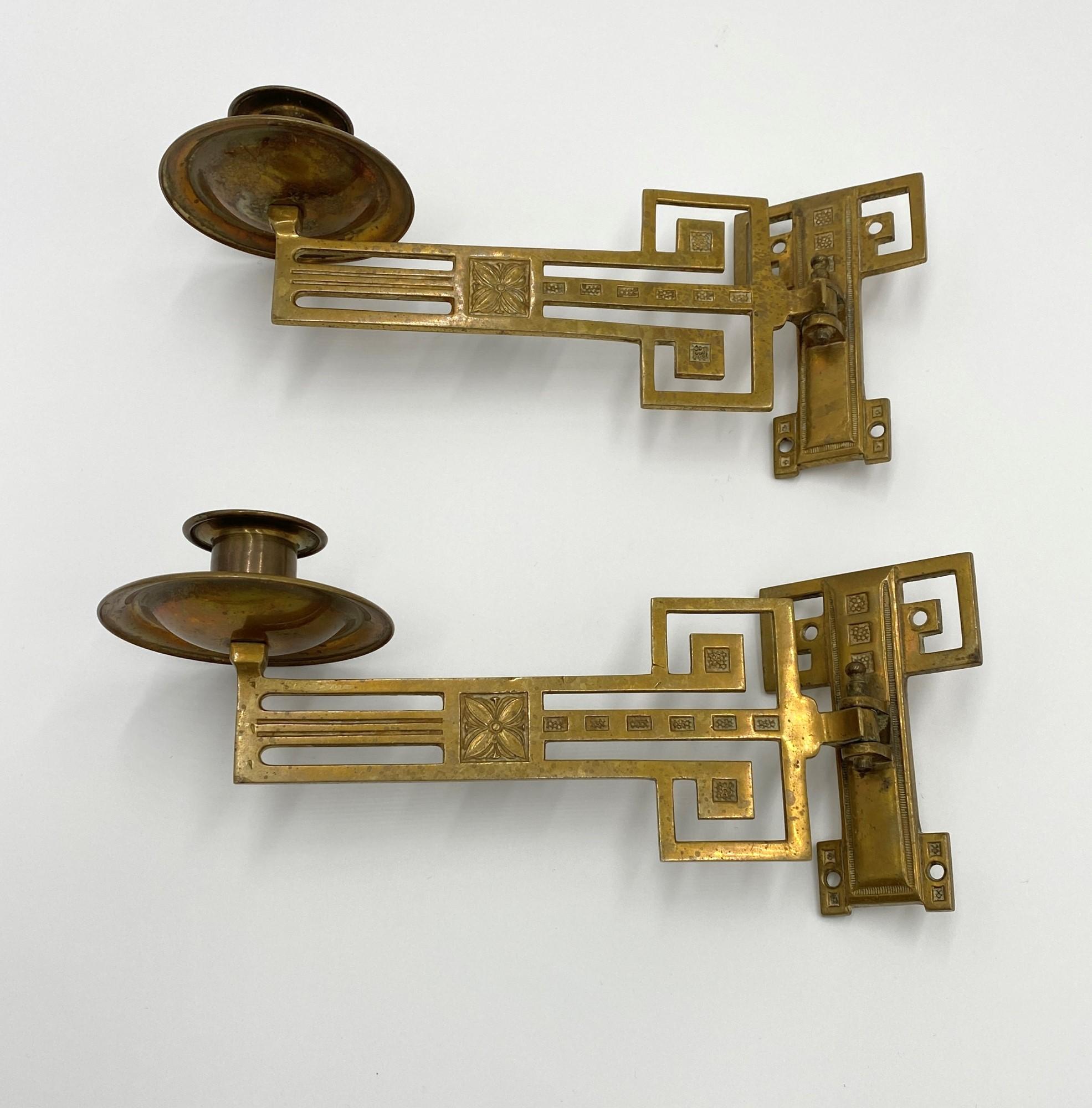 Adjustable late 19th century Victorian style piano sconces. Solid brass with geometric details and a floral motif in the each arm. One arm each. These are not wired. Priced as a pair. This can be seen at our 333 West 52nd St location in the Theater