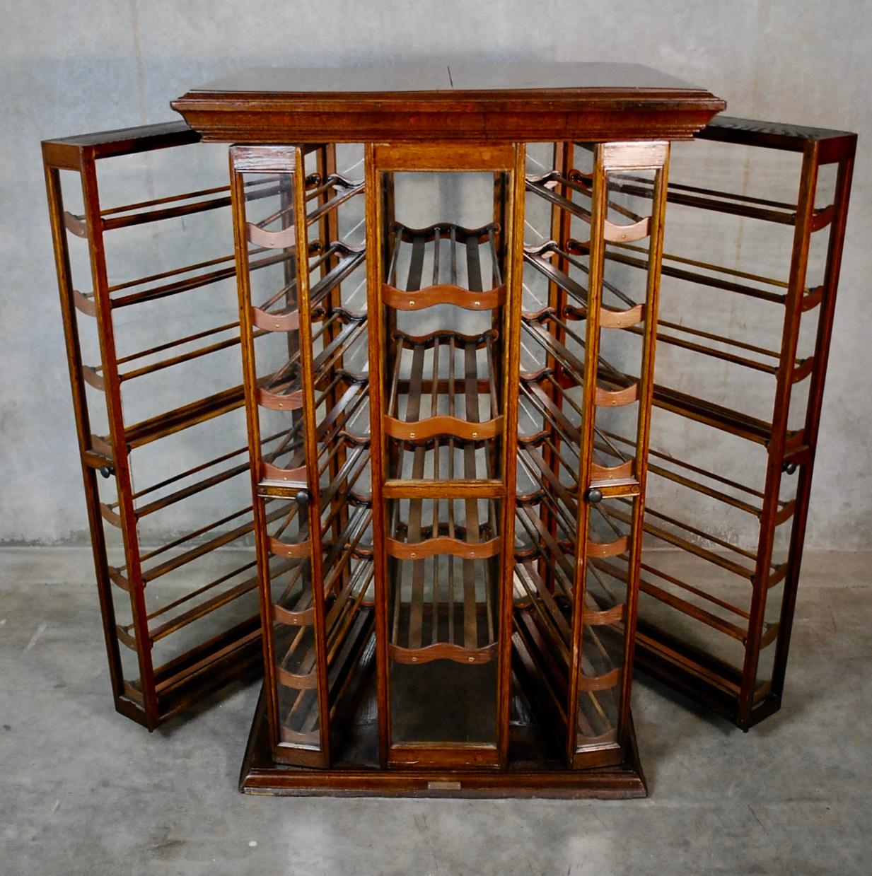 An Exhibition Showcase Company ribbon, spool cabinet, Erie, Pennsylvania & Guelph Ontario. Built cherry frame with swinging glass doors and panels. 
Henrich's Patent November 1895. 
Ideal for holding wine bottles.