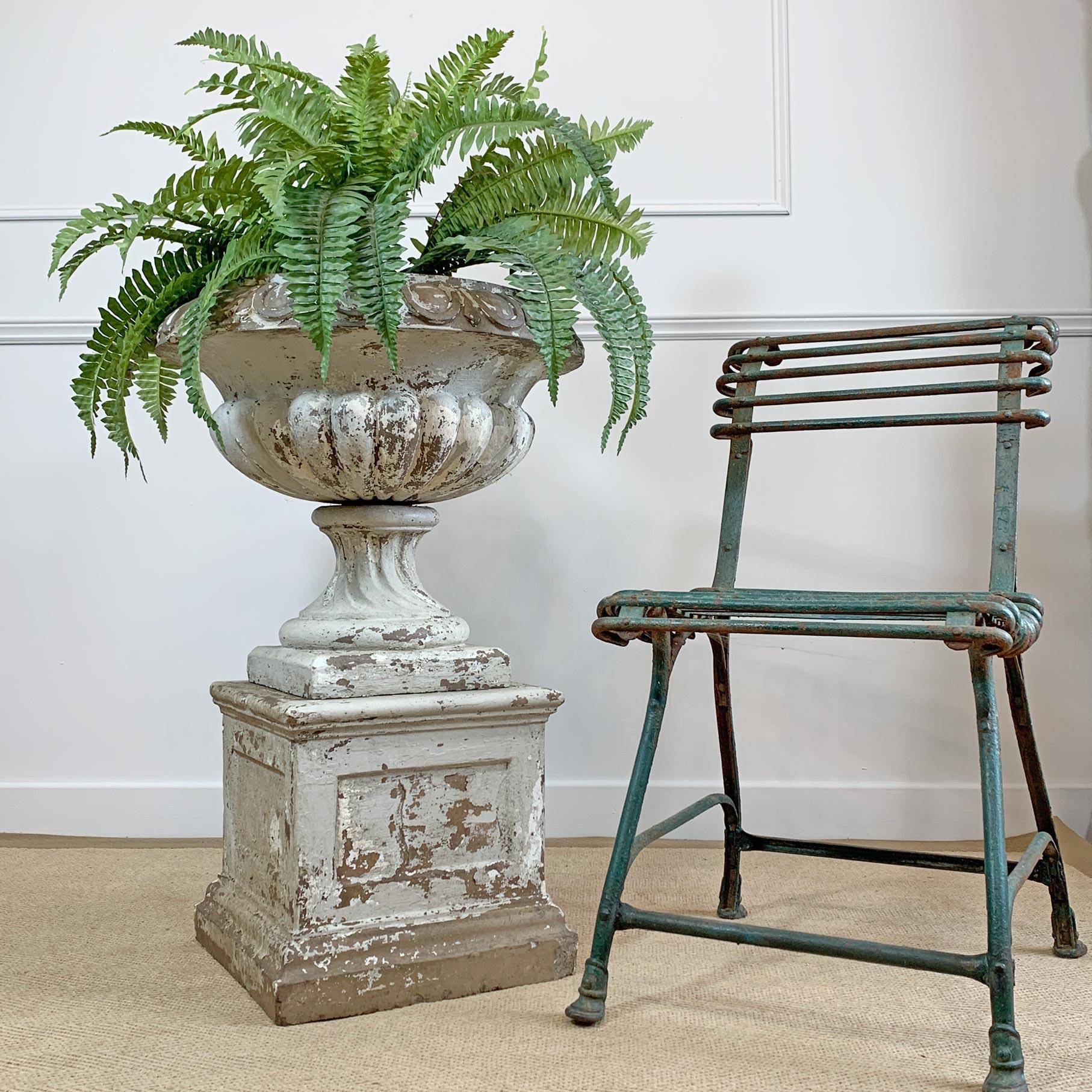 Late 19th-early 20th century terracotta tazza urn and plinth
This urn is in buff terracotta with weathered white paint and natural green tones from age and outdoor living
The urn is in 3 sections, bowl, stem and plinth. There is a historic chip to