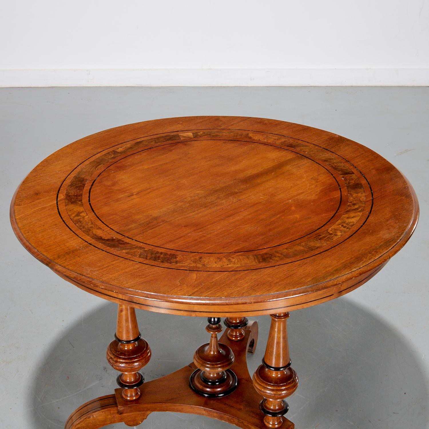 Late 19th c. England, a Victorian parcel ebonized walnut center table with a round top, turned baluster supports ending on a tripod base.

Dimensions:
29