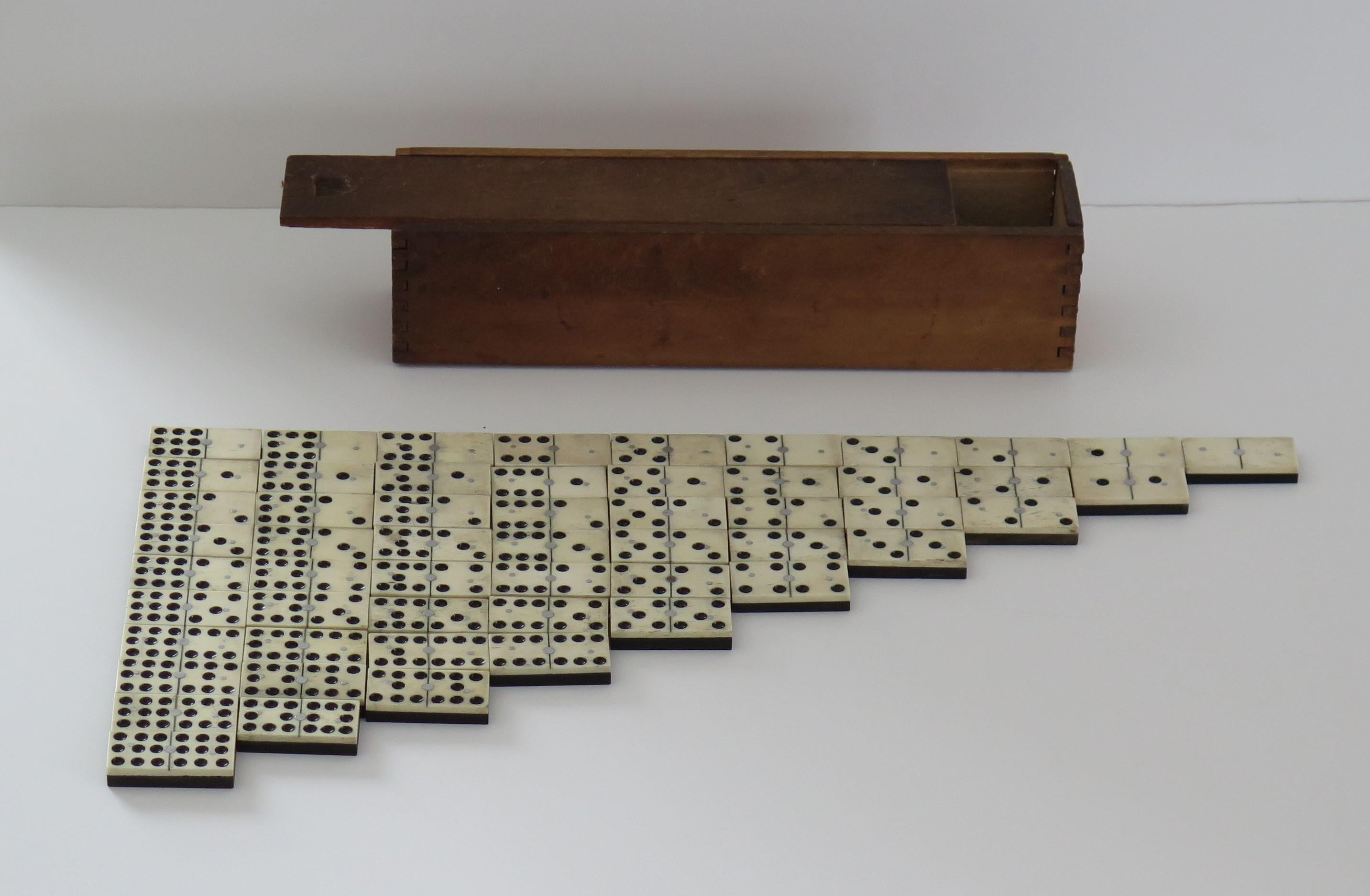 Dies ist eine seltene und originelle '9 Spot' Dominoe Spiel von 55 einzelnen Dominosteinen, die komplett mit seiner gegliederten Holzkiste oder Fall.

Domino-Sets bestehen in der Regel aus sechs Feldern, die insgesamt 28 Dominosteine ergeben.
Dieses