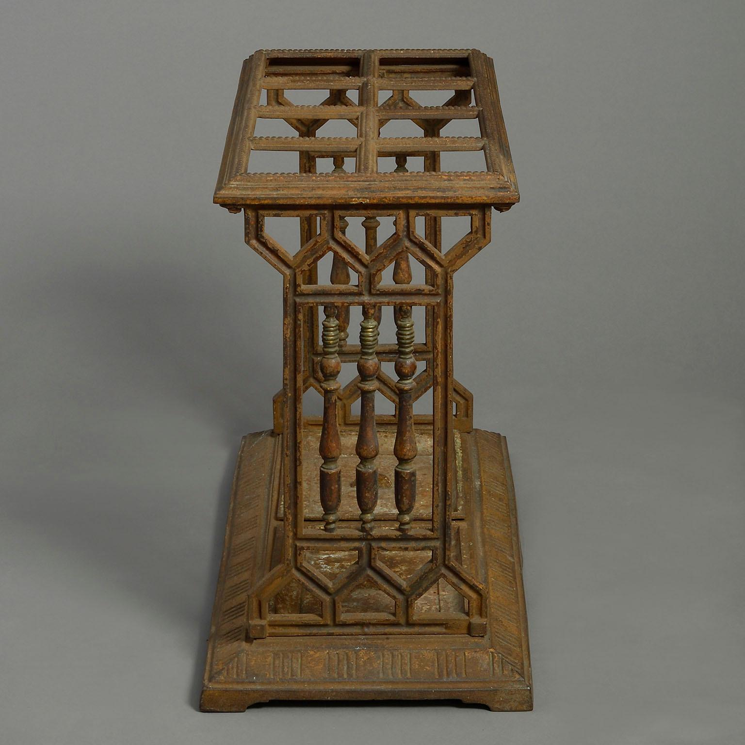 A late nineteenth century Aesthetic Movement cast iron stick and umbrella stand, the eight square divisions set upon balustraded ends, the base with two drip pans.

Circa 1880 England

Dimensions: 27 W x 13.5 D x 21.5 H inches
69 W x 34 D x 55
