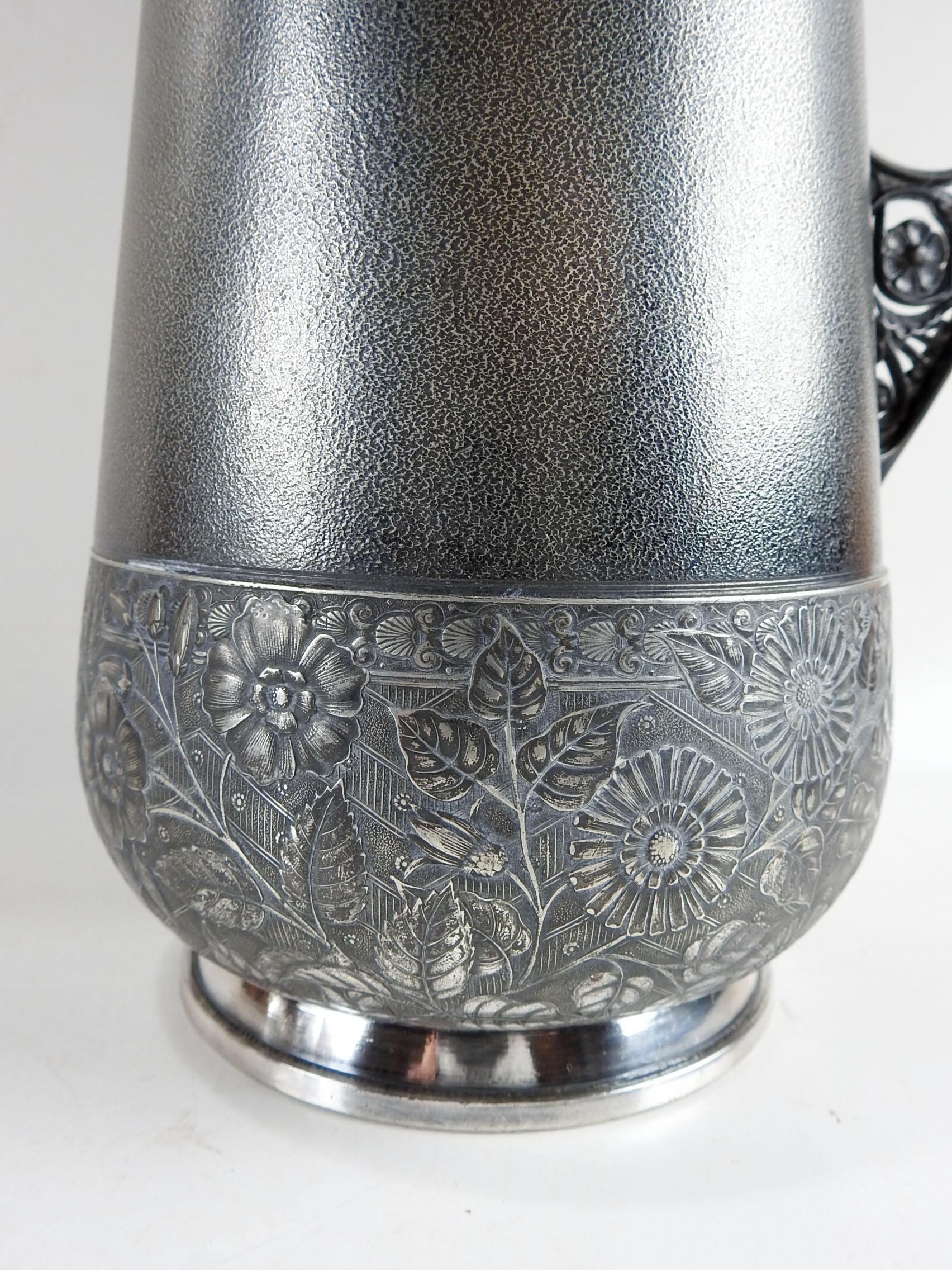 Circa 1880's Aesthetic Movement silverplate pitcher. Handsome original dark patina with floral bands and textured body. Marked Meriten Silver Co. on bottom. Some plate loss on handle.