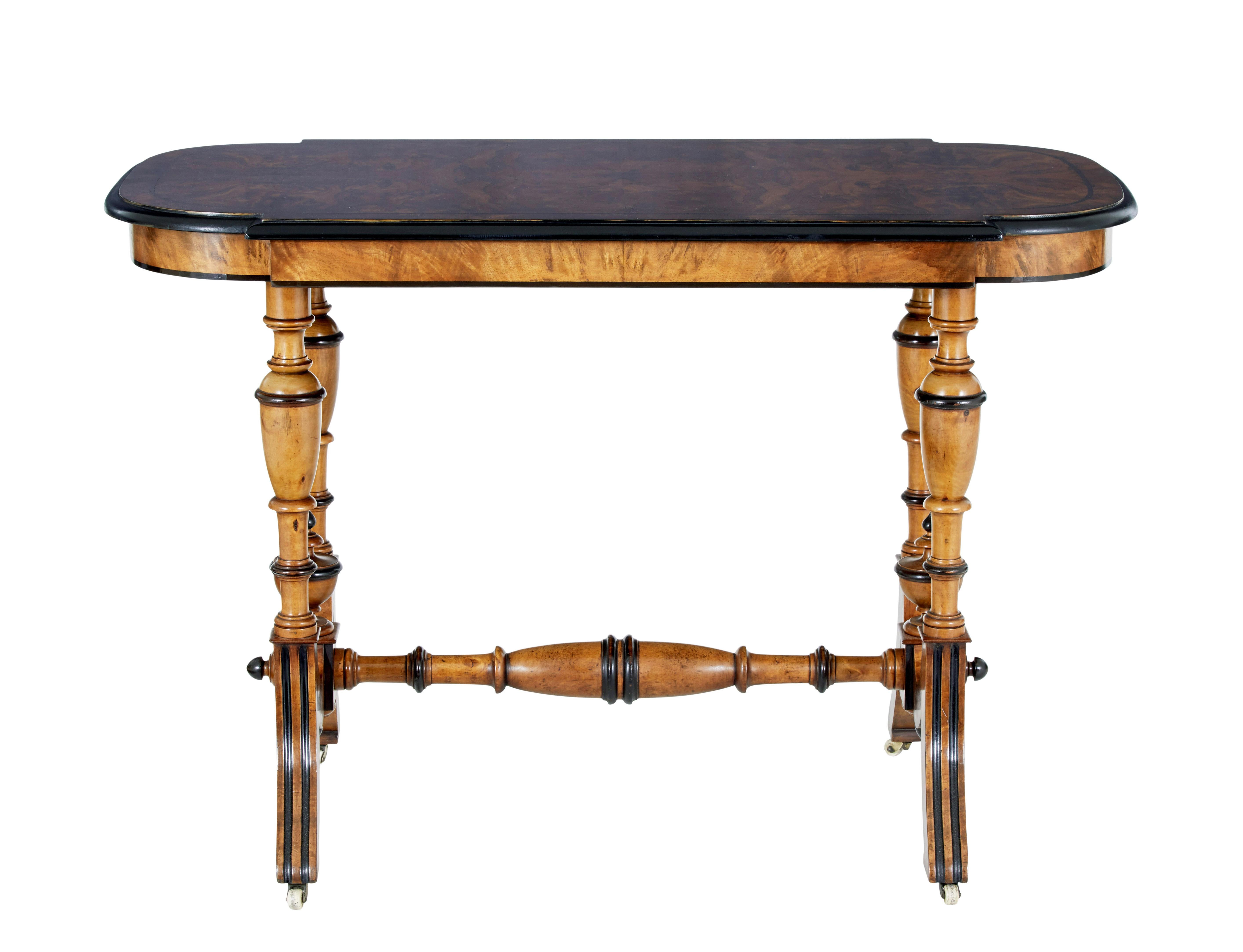 Late 19th century aesthetic movement walnut occasional table circa 1890.

Shaped top surface with matched burr walnut veneers, ebony stringing and ebonised outer edge.  Supported by 4 turned legs and stretcher, all with further ebonised elements and