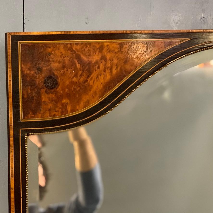 Super quality and very decorative English 19th century overmantel or console table mirror with burr amboyna, box stringing and a black lacquered, finished with micro brass beading throughout the frame.
All three beveled mirrors are the original and