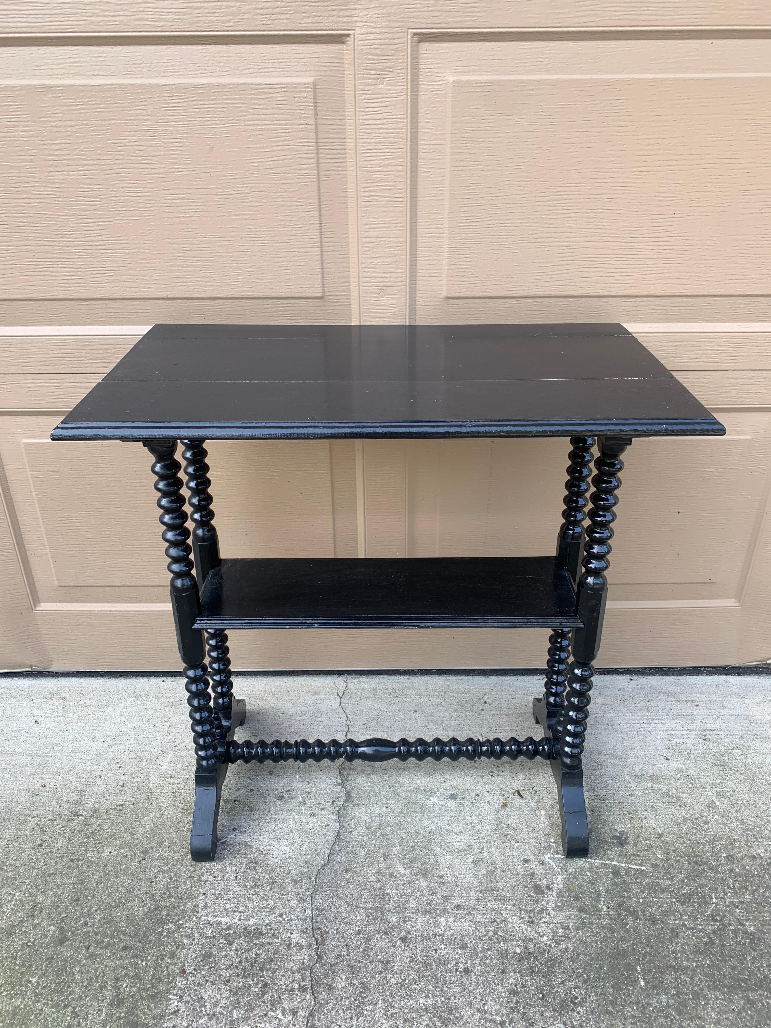 Preciosa mesa auxiliar victoriana de nogal pintado de negro con un estante inferior y patas y bastidor tallados de estilo carrete o bobina.

EEUU, Circa finales del siglo XIX

Medidas: 26,5