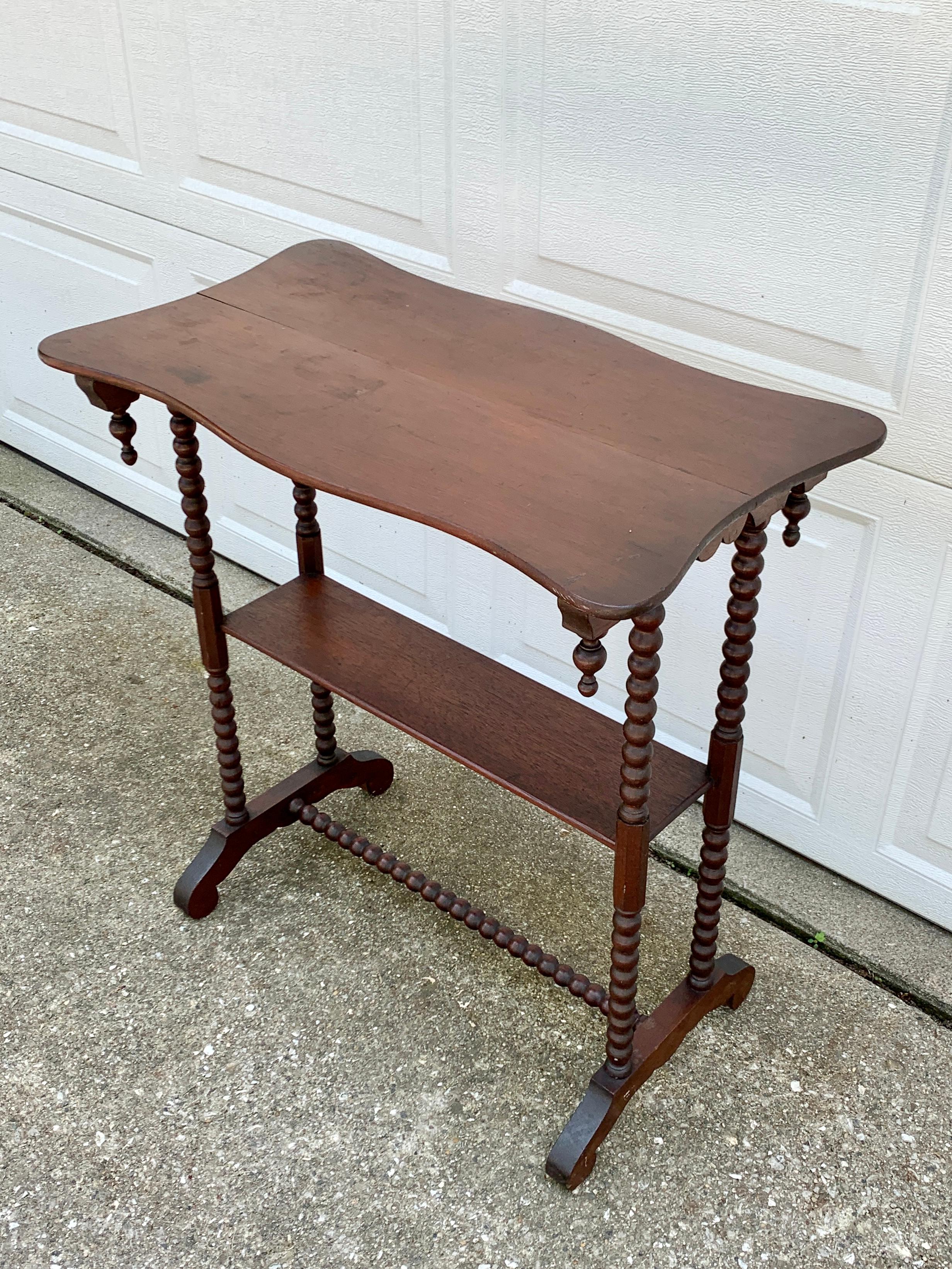 A gorgeous Victorian walnut side table with a lower shelf and carved finial details

USA, circa late 19th century

Measures: 26.25