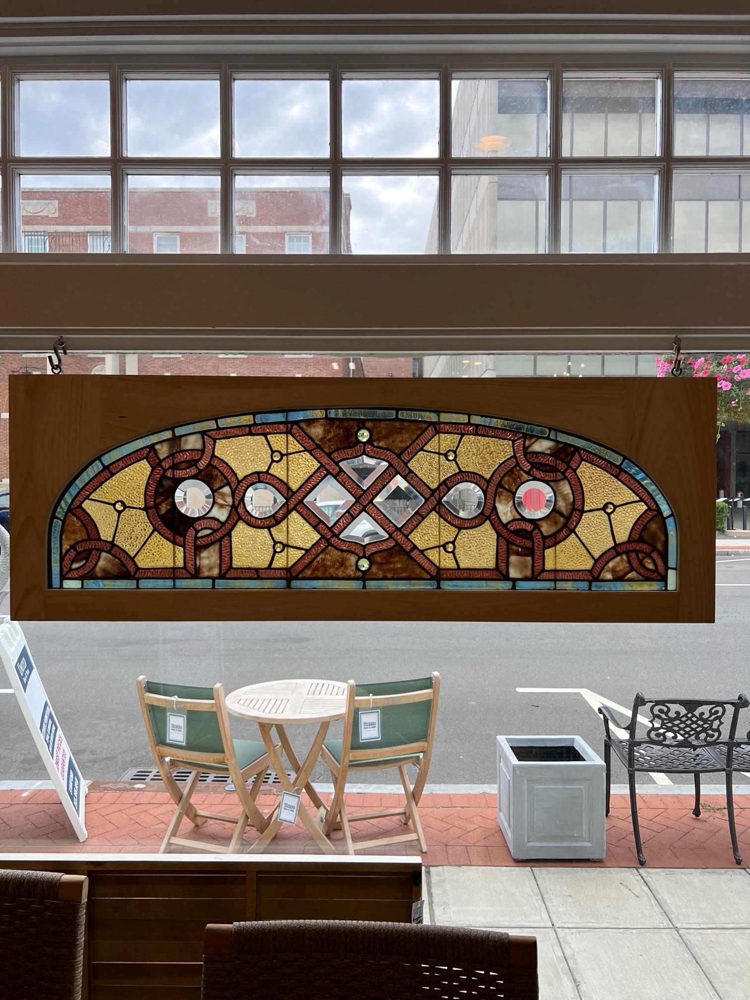 Beautiful 19th century antique arched top stained glass transom window in a new wood frame. This is a combination window with both stained glass with jewels and beveled glass with great natural colors. Salvaged from an estate outside Pittsburgh PA.