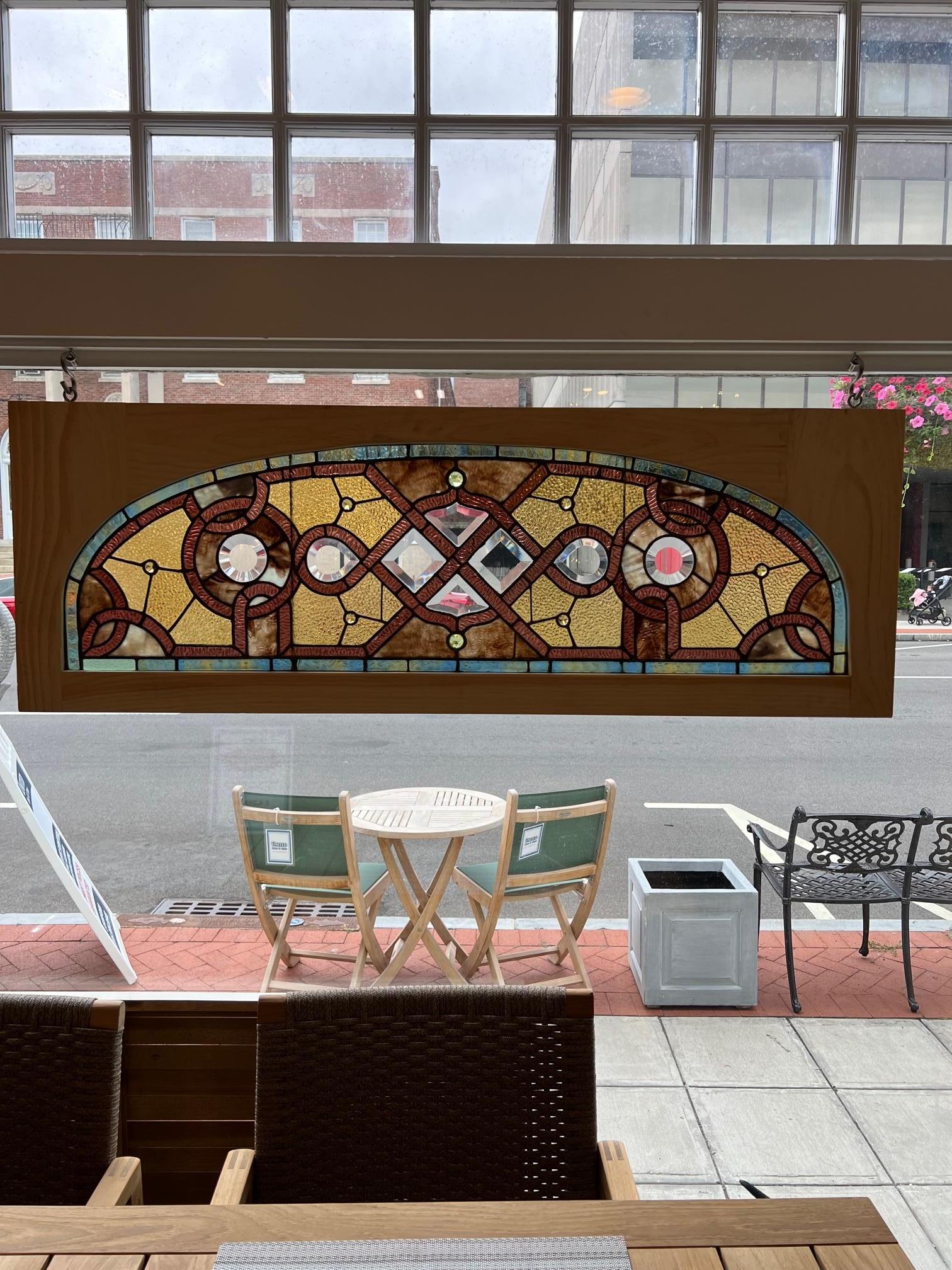 This is one of two matching 19th century antique arched top stained glass transom windows in a new wood frame. The other window is also listed on 1st Dibs only a few minor differences. This is a combination window with both stained glass and beveled