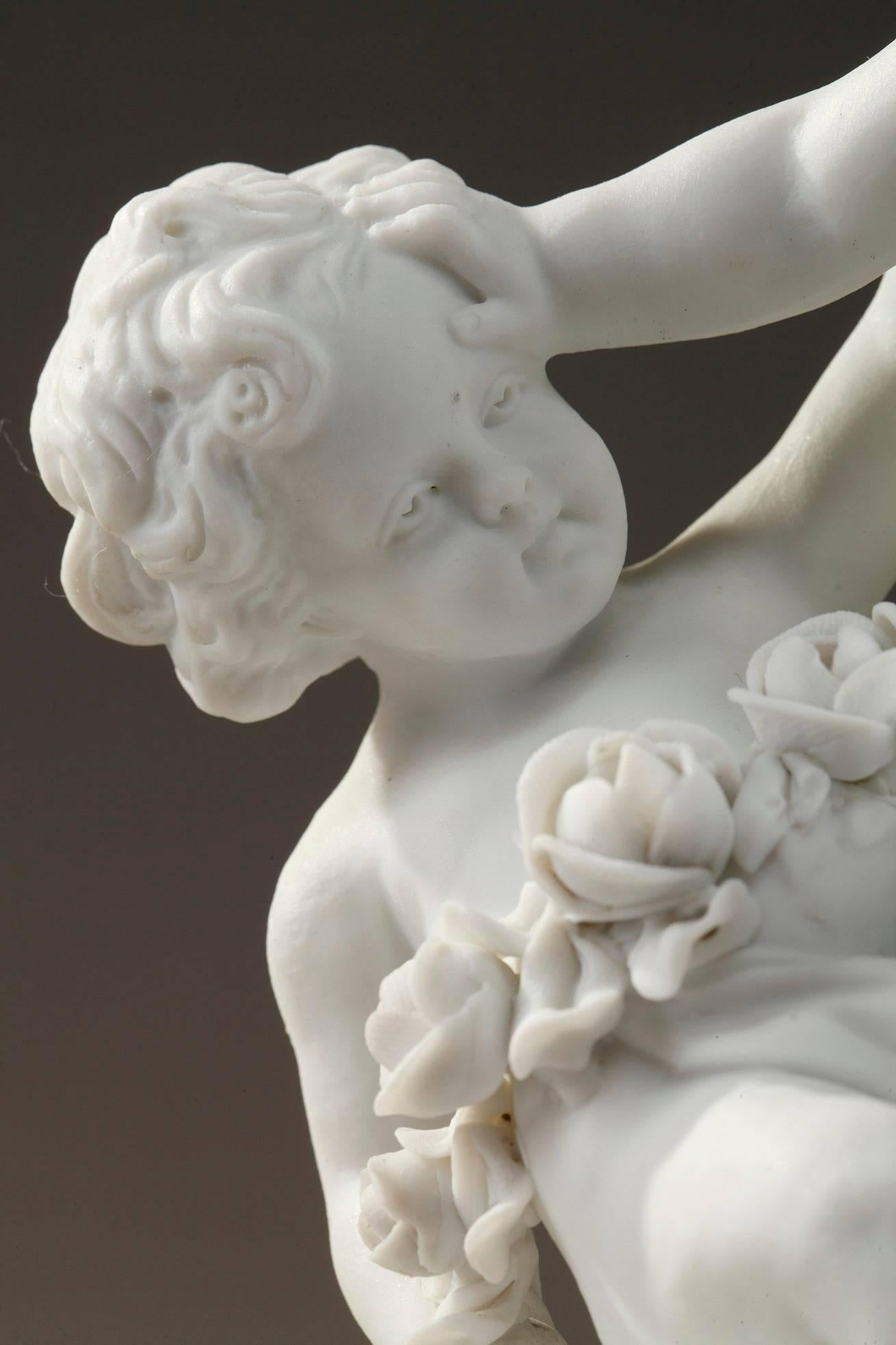 Deux groupes de figurines en porcelaine biscuit fine:: chacun d'eux représentant trois jeunes et charmants enfants jouant. L'un d'eux porte une guirlande de roses autour du cou. Ils reposent sur une base circulaire cannelée naturaliste. Marque