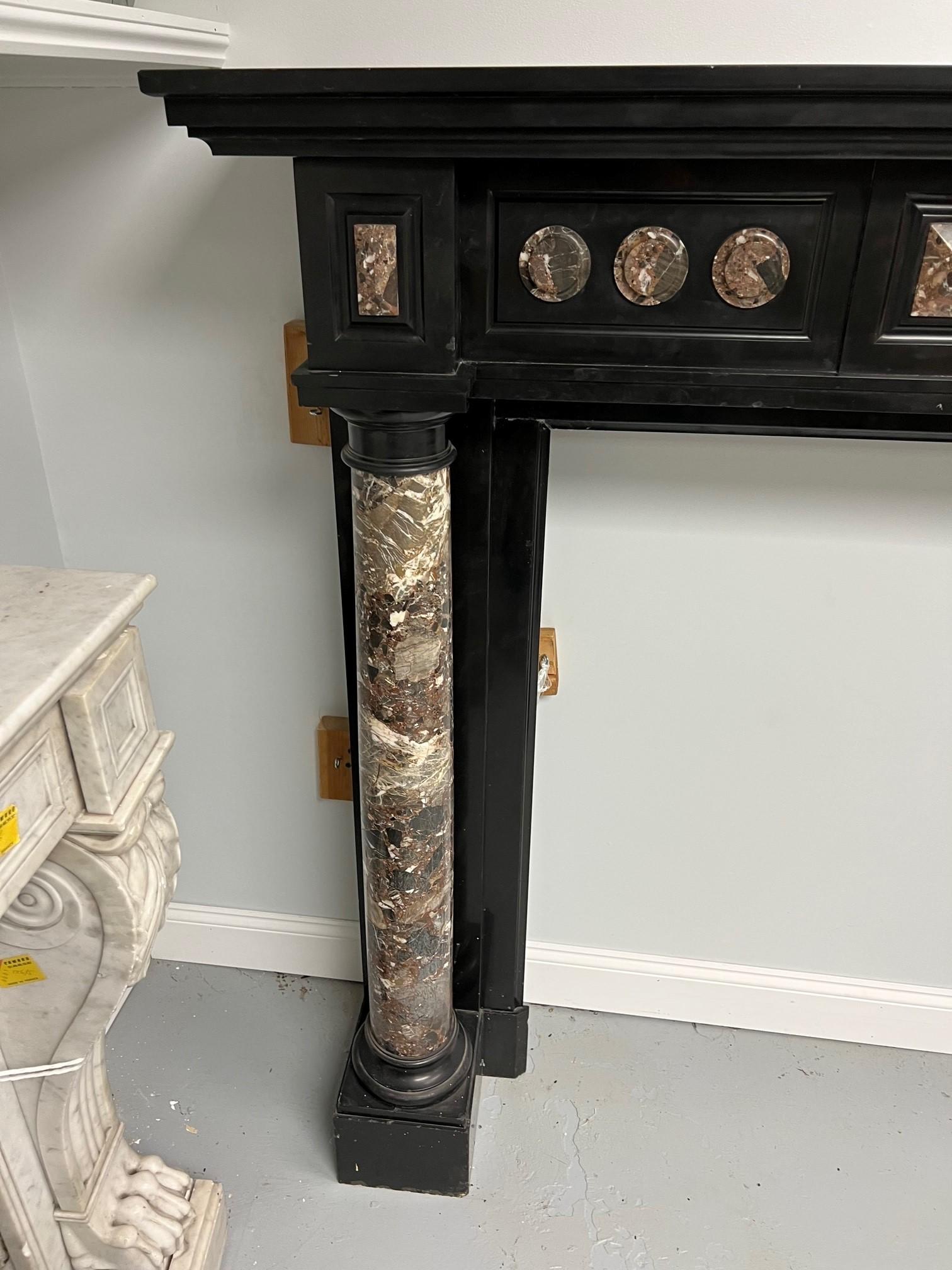 Late 19th century antique Belgian black marble fireplace mantel with marble columns. This is a nice tall mantel and the marble columns have a beautiful pattern with great color tones. Salvaged years ago from an estate in France outside of Paris and