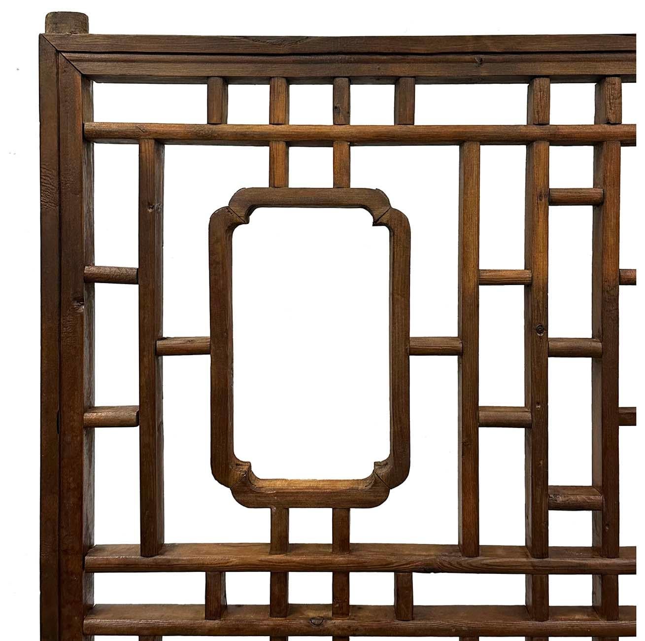 Ce grand panneau de fenêtre intérieure en orme sculpté de la fin de la dynastie Qing, datant de la fin du XIXe siècle, avec un motif ajouré, a été créé en Chine pendant la dynastie Qing, dans les dernières années du XIXe siècle. Ce panneau de