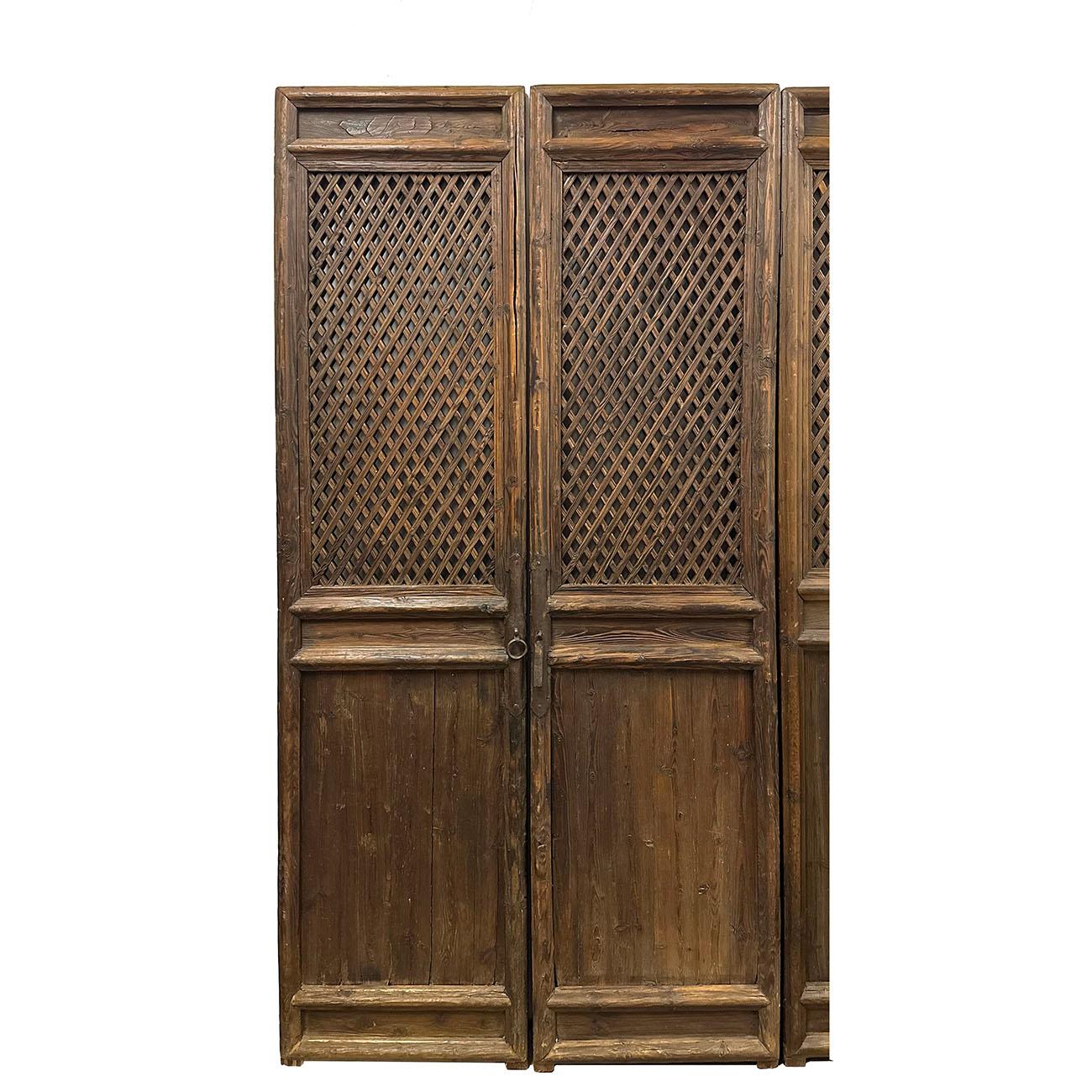 A set of four Chinese Qing Dynasty period large carved elm wood interior door panels from the late 19th century, with fretwork design, Created in China during the Qing Dynasty in the later years of the 19th century, each of this set of four of large