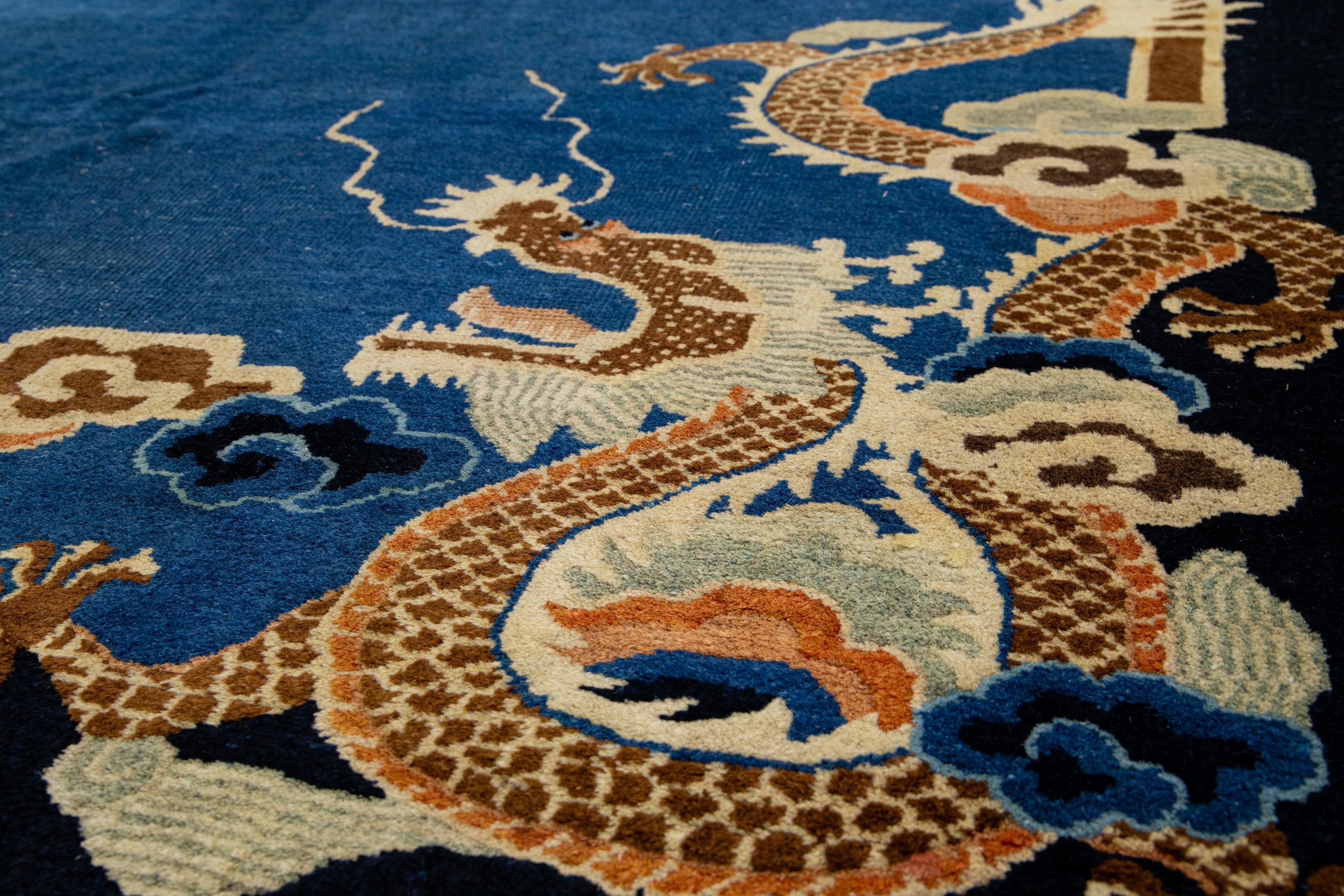 Magnifique tapis chinois Art Déco Peking en laine nouée à la main avec un champ bleu marine, le cadre de bleu foncé. Ce tapis présente des accents de beige, de pêche et de brun dans un subtil motif de dragon chinois classique sur toute sa