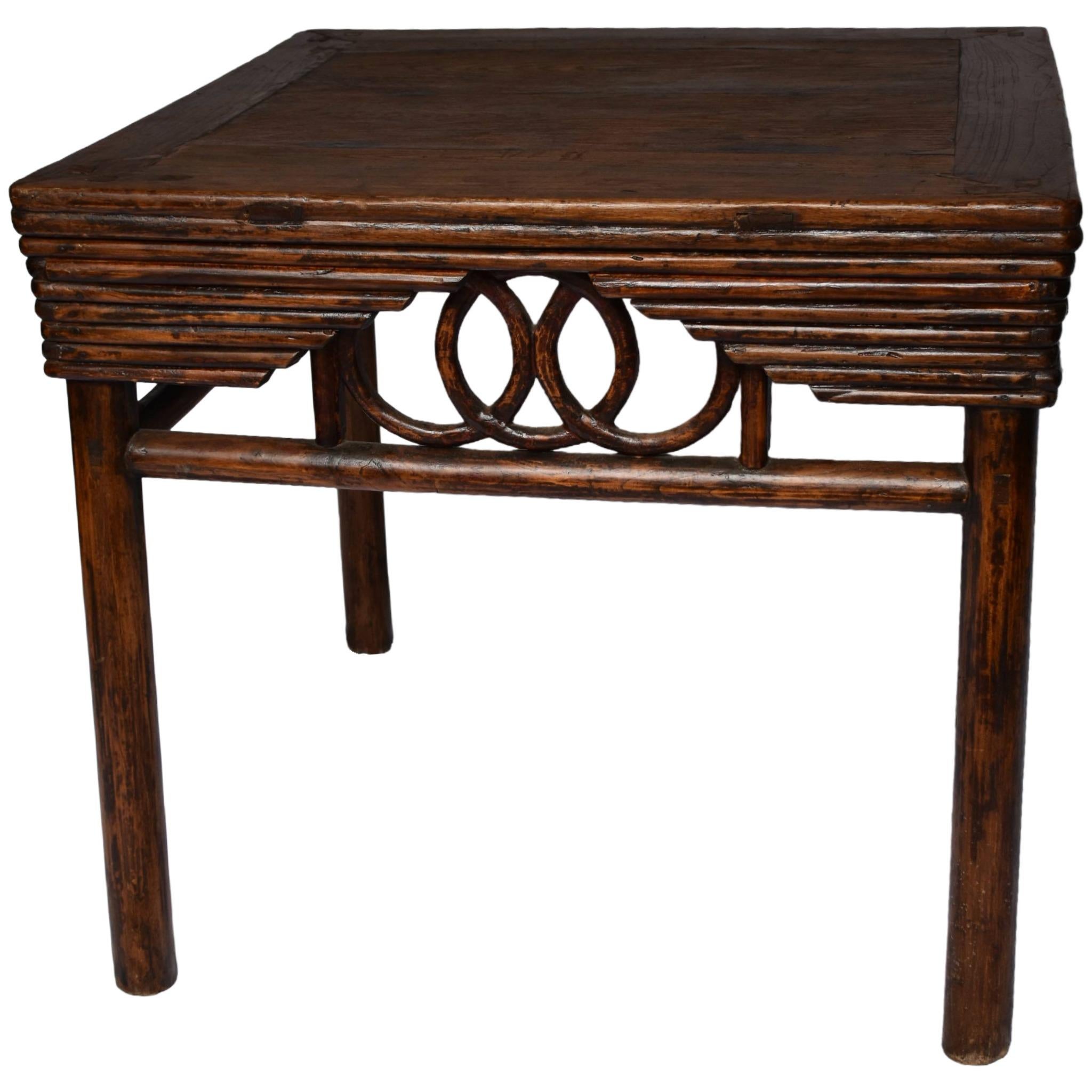 Exemple raffiné de l'artisanat de la dynastie Qing, cette table à vin du XIXe siècle présente un tablier délicatement sculpté avec des détails en bambou courbé, des frettes ouvertes et des courbes fluides, le tout équilibré par des pieds ronds et