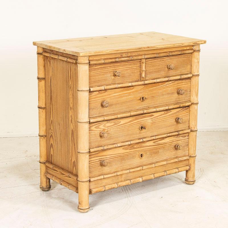 This English chest of drawers was crafted with a faux bamboo exterior which was a style statement during the late 1800's. Balance with 2 smaller drawers over 3 larger drawers, it has been stripped down to the natural pine leaving a fresh, soft feel