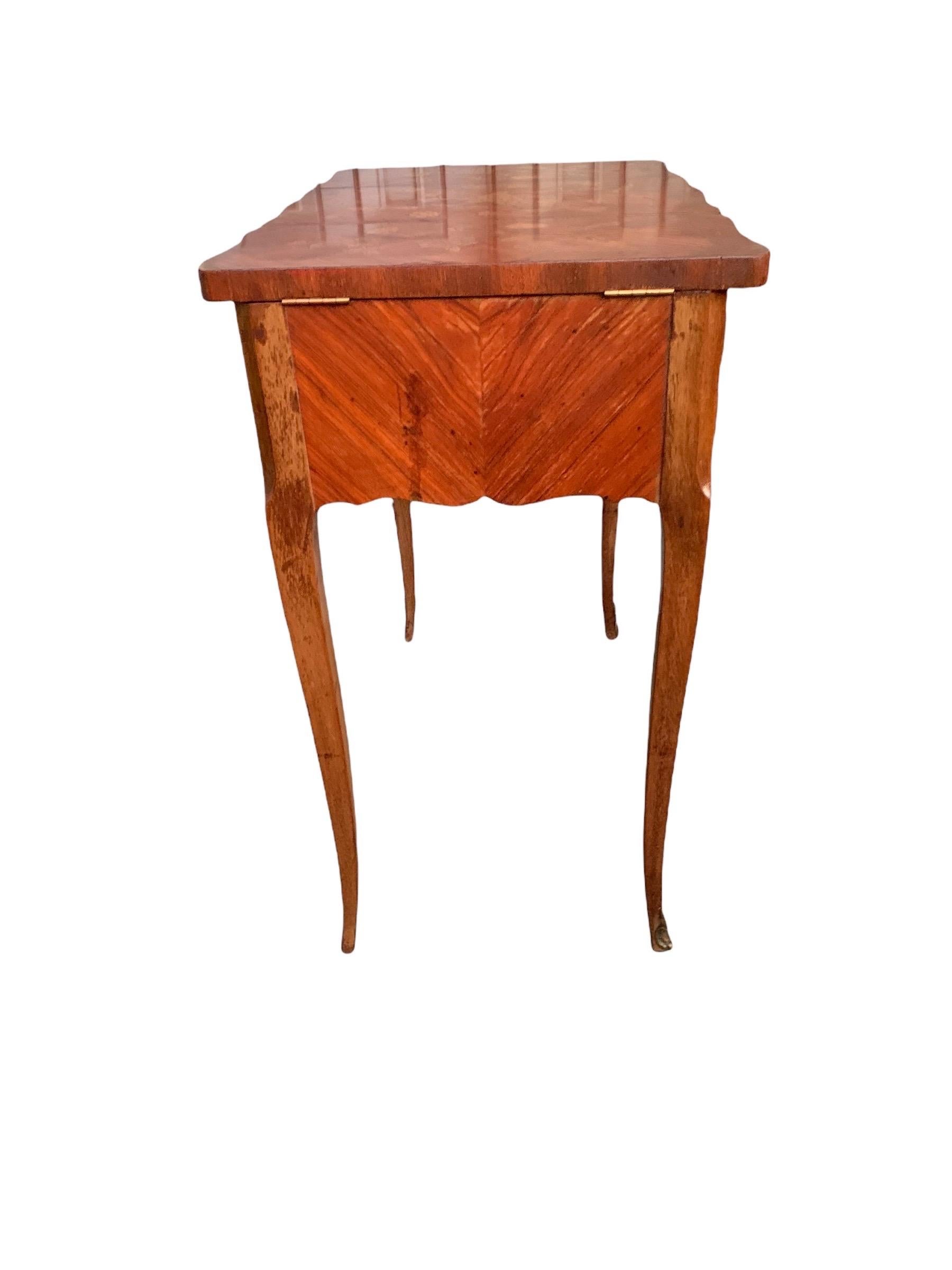 A lovely antique French, Louis XV style, rosewood, kingwood and tulipwood marquetry Poudreuse (or ladies dressing vanity) , the gently scalloped top with three hinged lids, all locking together with a key and decorated with lavishly inlaid flowers