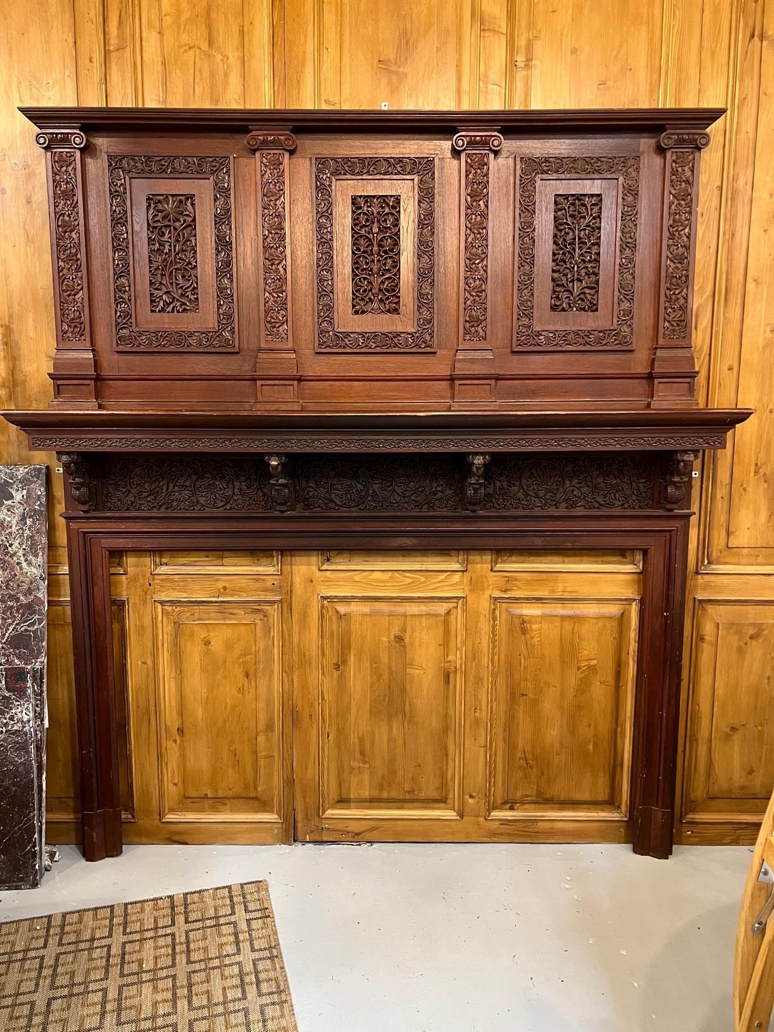 Late 19th century carved wooden fireplace mantel salvaged from a historic New Haven CT. estate. This is a beautiful hand carved wooden fireplace mantel that instead of a mirror above it has three intricately carved wooden panels. I believe the wood