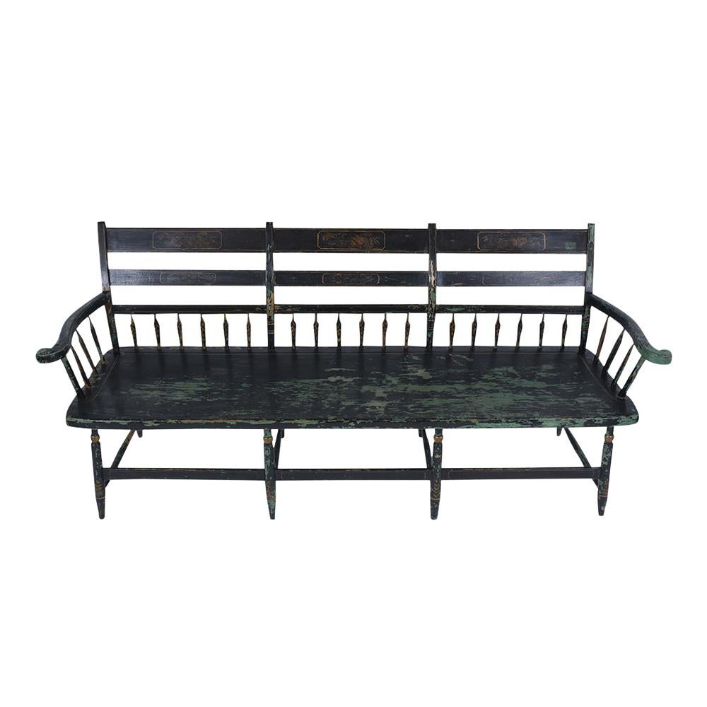 This Antique 1890's Painted Bench is in very good condition and has its original black color has been newly waxed and polished developing a beautiful patina finish. This bench has hand-carved details, features carved armrests, a supportive spindle