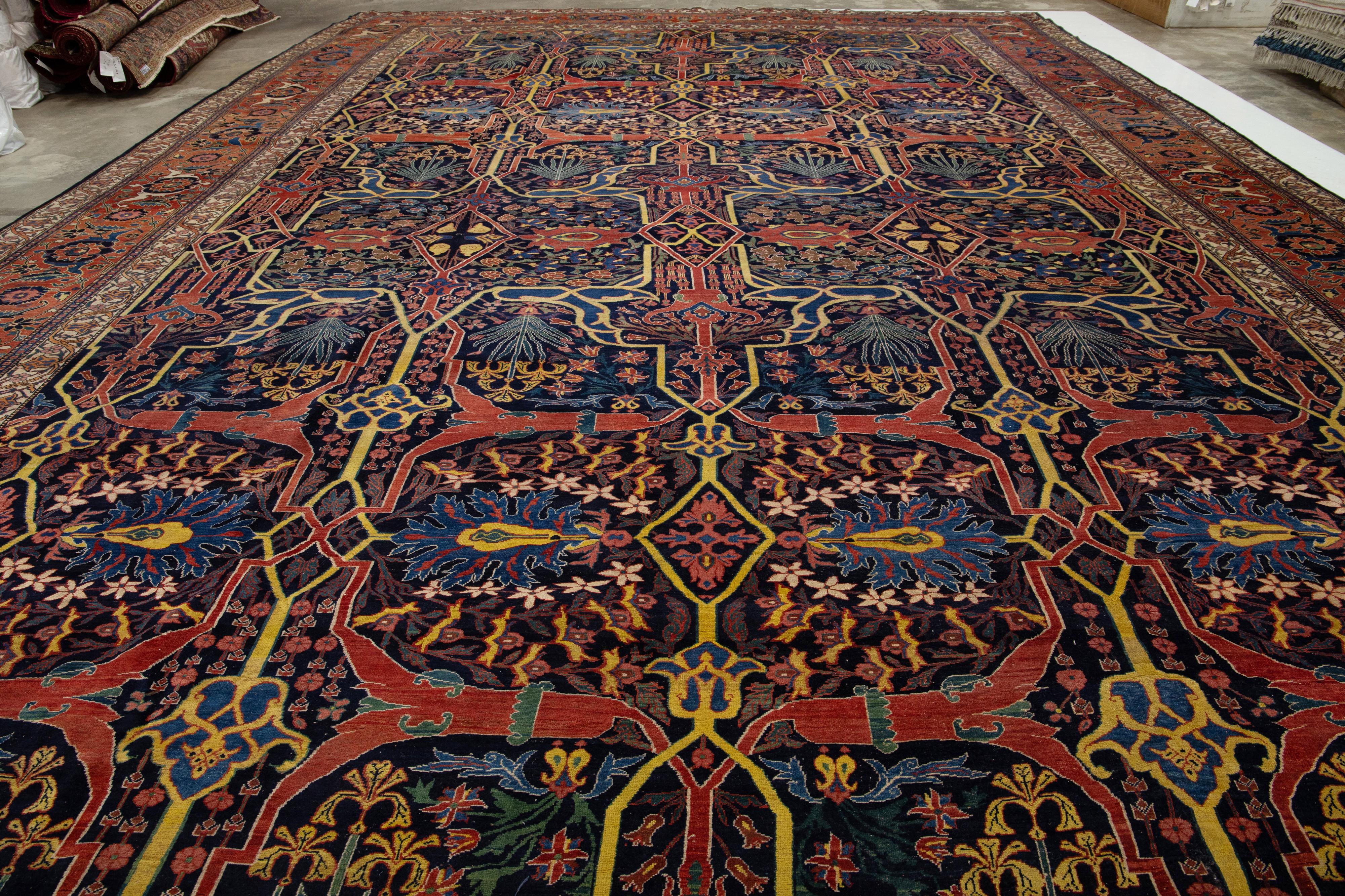 Presenting the exceptional antique One of the kind Bidjar Persian rug, a remarkable hand-knotted masterpiece crafted from wool, showcasing a grand palace size. This rug showcases an exquisite navy blue field embellished with red-rust, beige, and