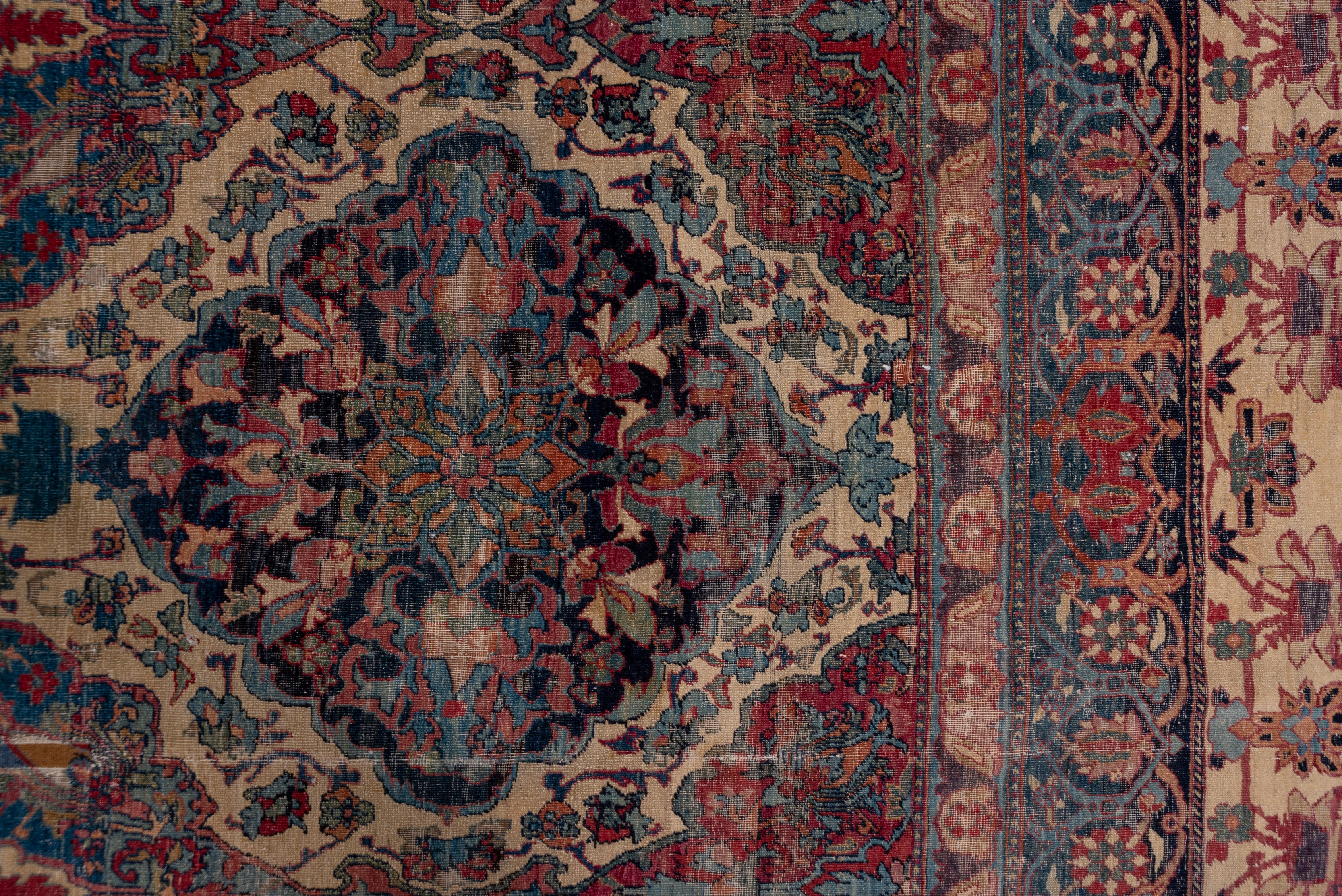 The pattern of cartouches stretches out towards one end, indicative of an early carpet before exact scale paper cartoons were the usual Kerman practice. The dark blue, pale blue and soft cochineal red scalloped medallions neatly fill the sandy