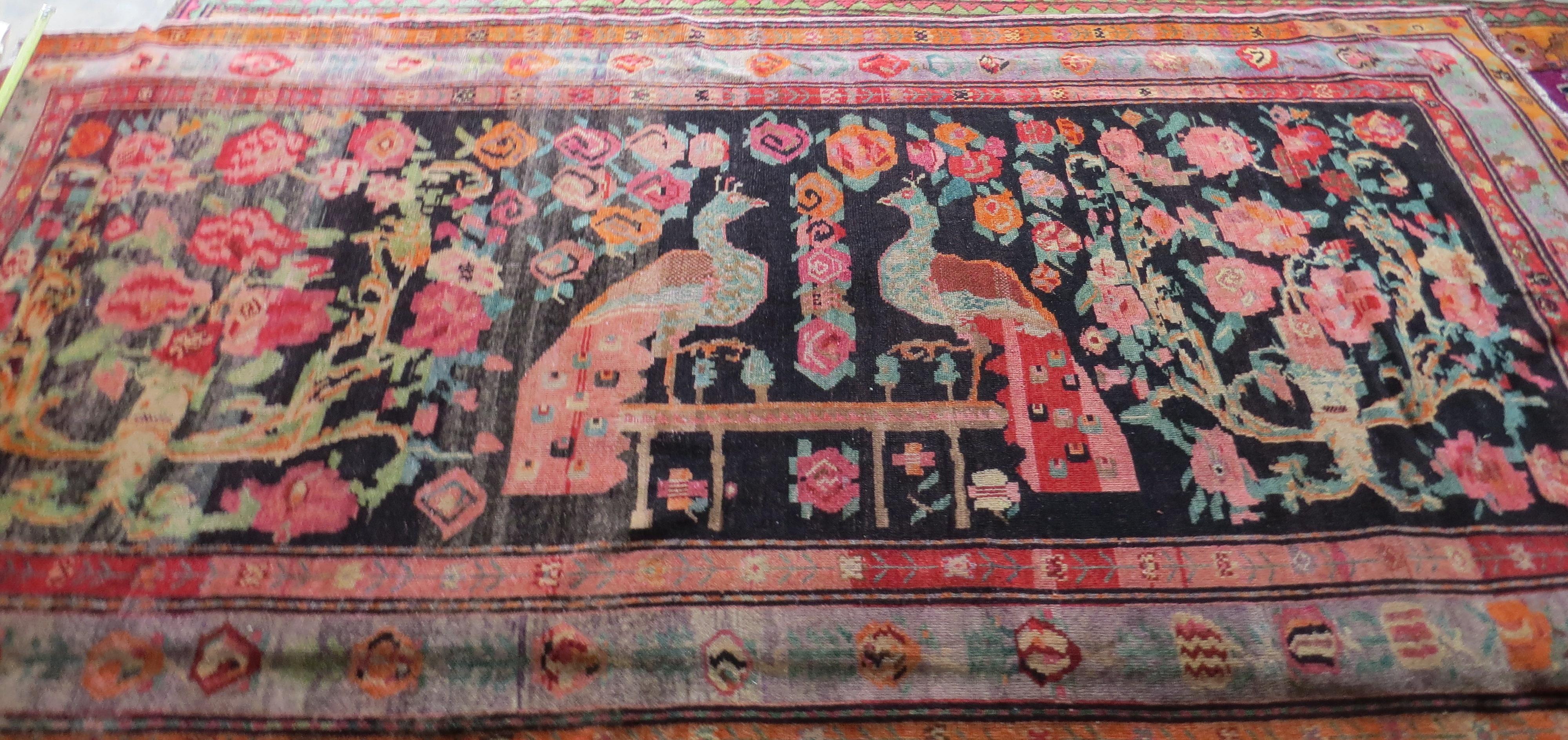 This hand knotted wool antique Caucasian Karabakh rug has an abrashed patina that comes from the many years of aging. Design. The abrashed red field displays two large scale peacocks. Rose bouquets composed of cabbage roses, peonies, floral sprigs,