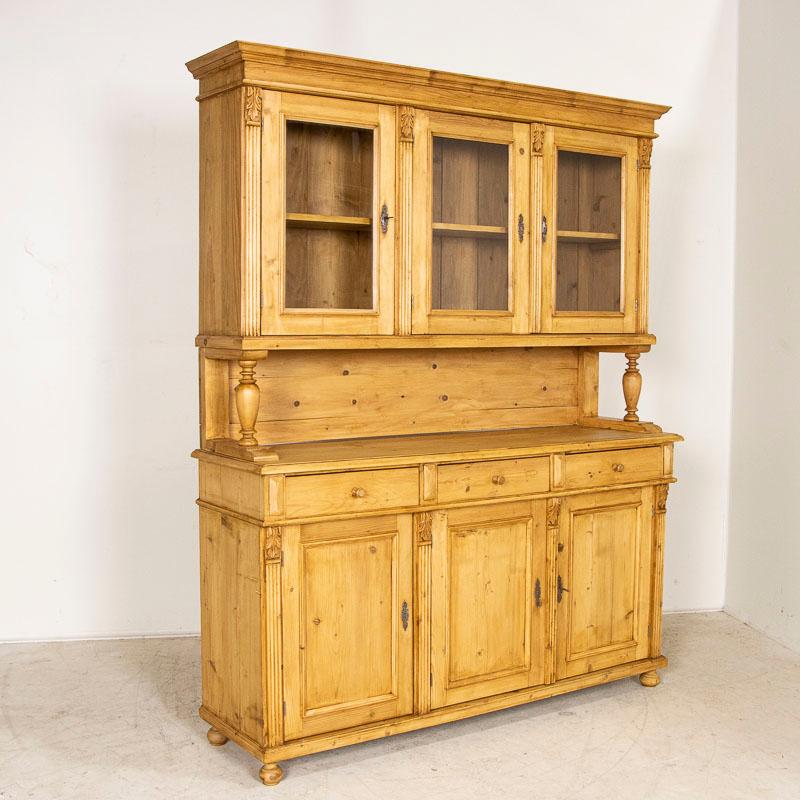 This pine cupboard has simple elements that make it special, such as the turned column accents and crown molding details along the top. This cupboard likely displayed the household china and serving ware in the 1800’s. The top section with glass