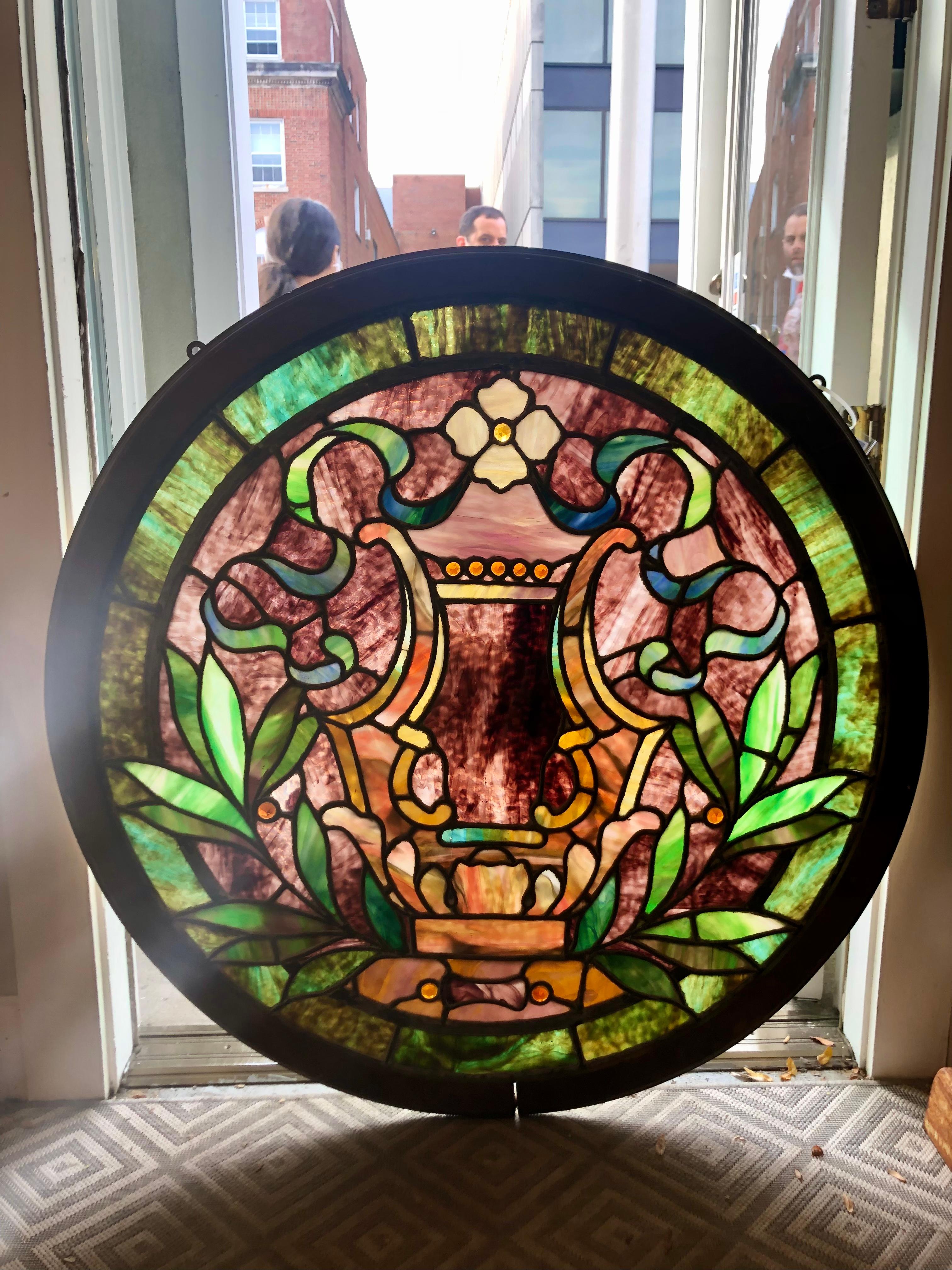 Late 19th century antique round stained glass window from upstate NY. This window has beautiful colors and is round which is hard to find. The stained glass window can hang in front of a window or in a interior wall its just a great window.